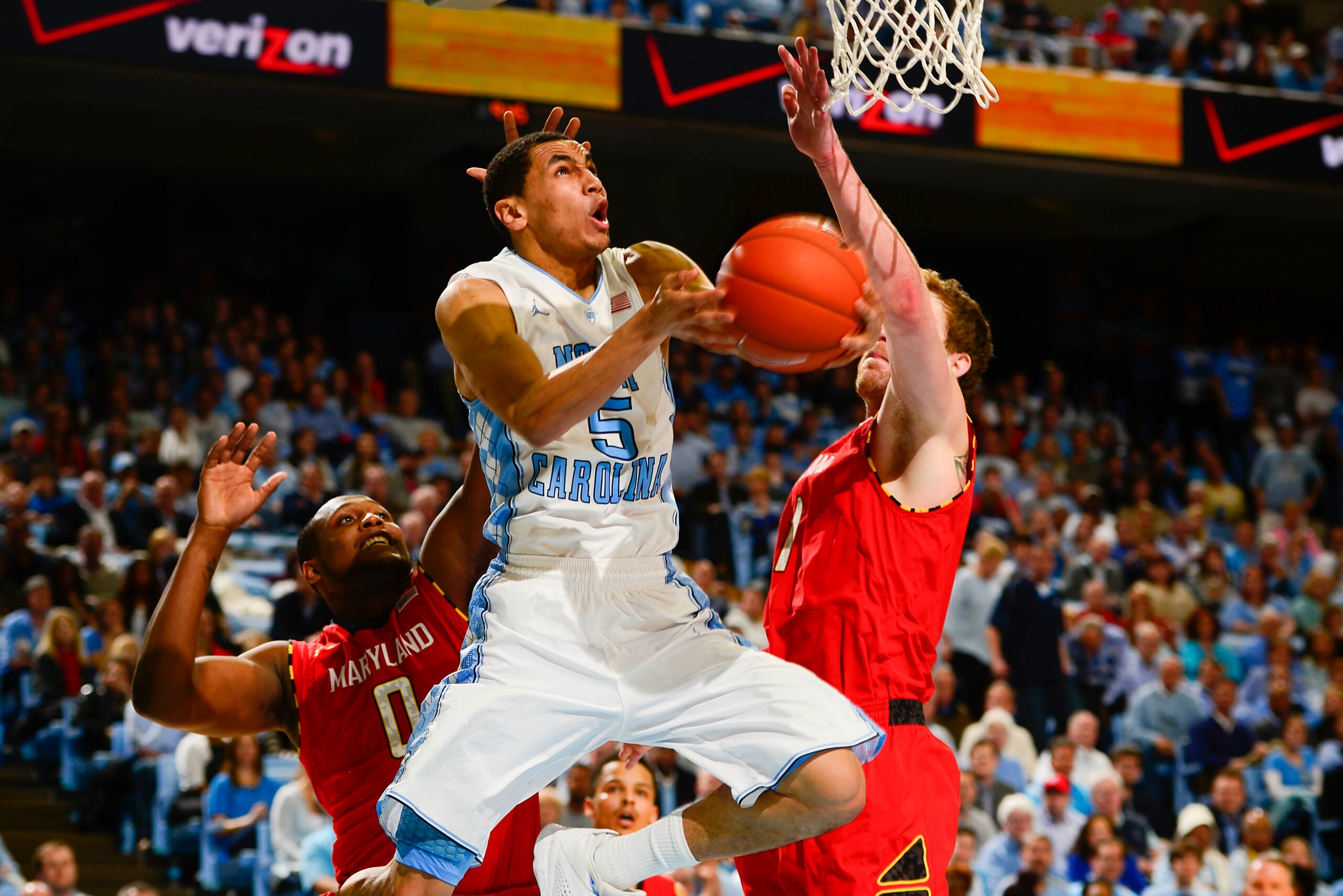 Feb 4, 2014; Chapel Hill, NC, USA; North Carolina Tar Heels guard Marcus Paige (5) scores as Maryland Terrapins forward Charles Mitchell (0) and forward Evan Smotrycz (1) defend in the second half. The North Carolina Tar Heels defeated the Maryland Terrap