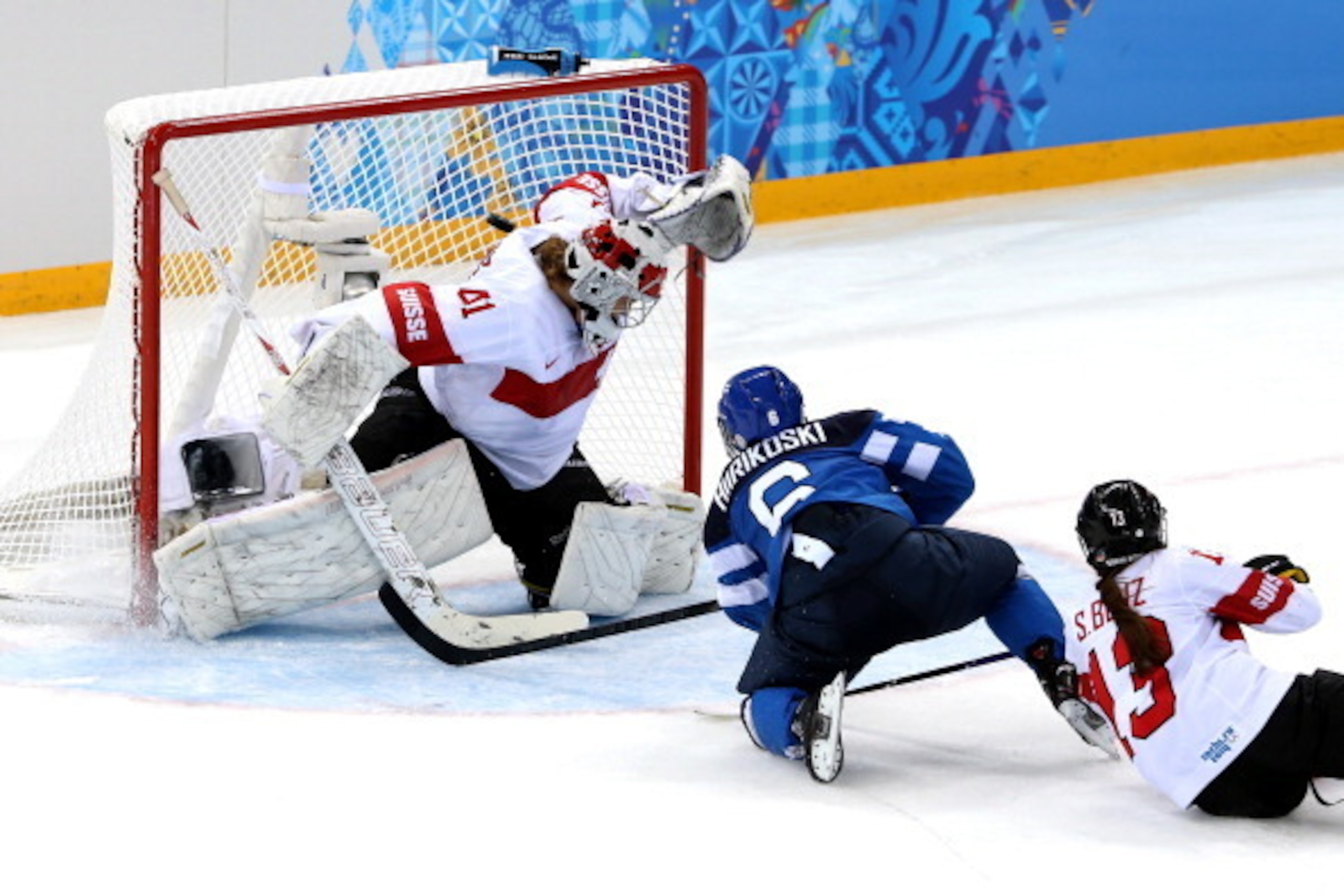 SOCHI, RUSSIA - FEBRUARY 12:  Jenni Hiirikoski #6 of Finland scores the game winning goal in overtime to against Florence Schelling #41 of Switzerland to defeat Finland 4 to 3 in the Women's Ice Hockey Preliminary Round Group A game on day five of the Soc