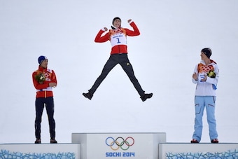 SOCHI, RUSSIA - FEBRUARY 12:  Gold medalist Eric Frenzel of Germany jumps in celebration alongside silver medalist Akito Watabe of Japan (L) and bronze medalist Magnus Krog of Norway (R) during the flower ceremony for the MenÂs Nordic Combined Individual 