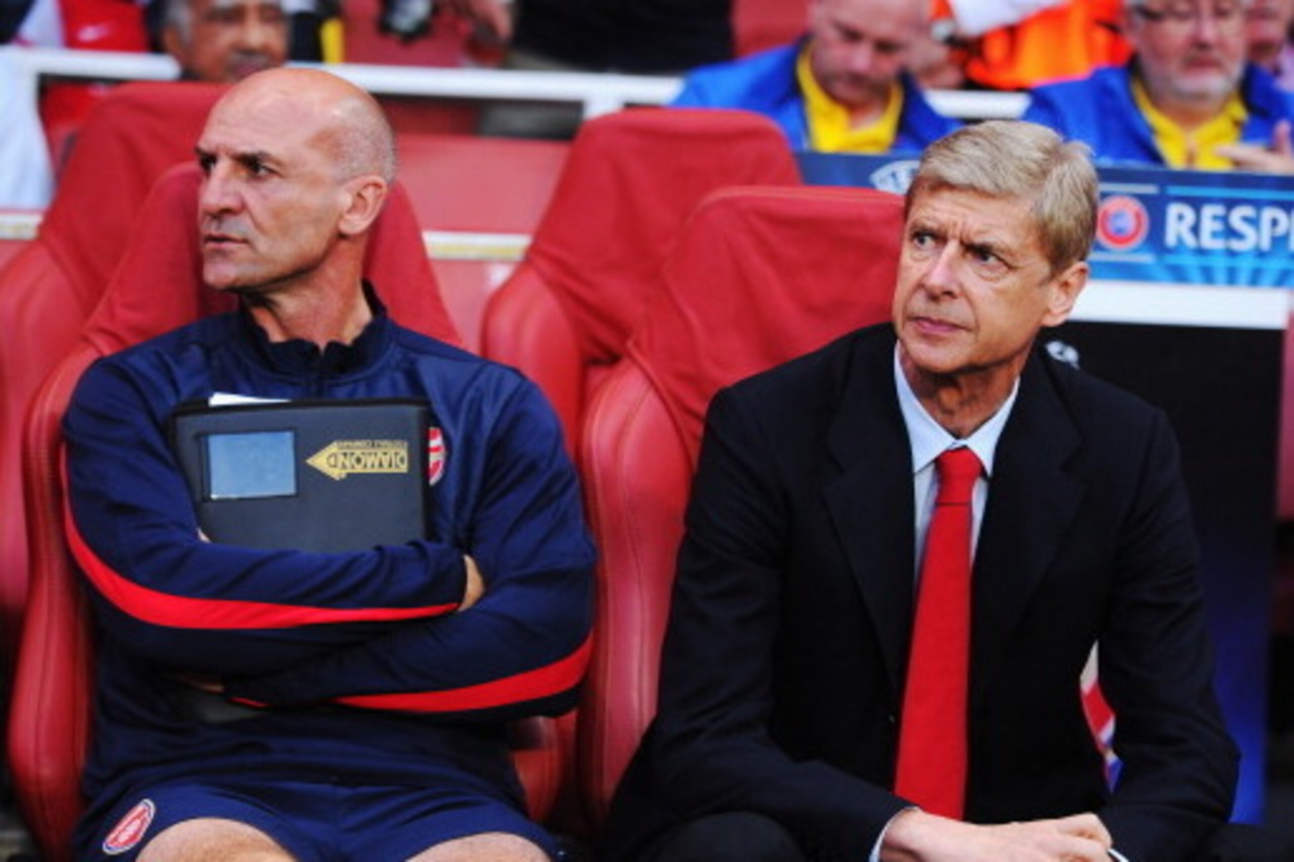 LONDON, ENGLAND - AUGUST 27:  Arsene Wenger (R) the Arsenal manager and assistant Steve Bould look on before the UEFA Champions League Play Off Second leg match between Arsenal FC and Fenerbahce SK at Emirates Stadium on August 27, 2013 in London, England