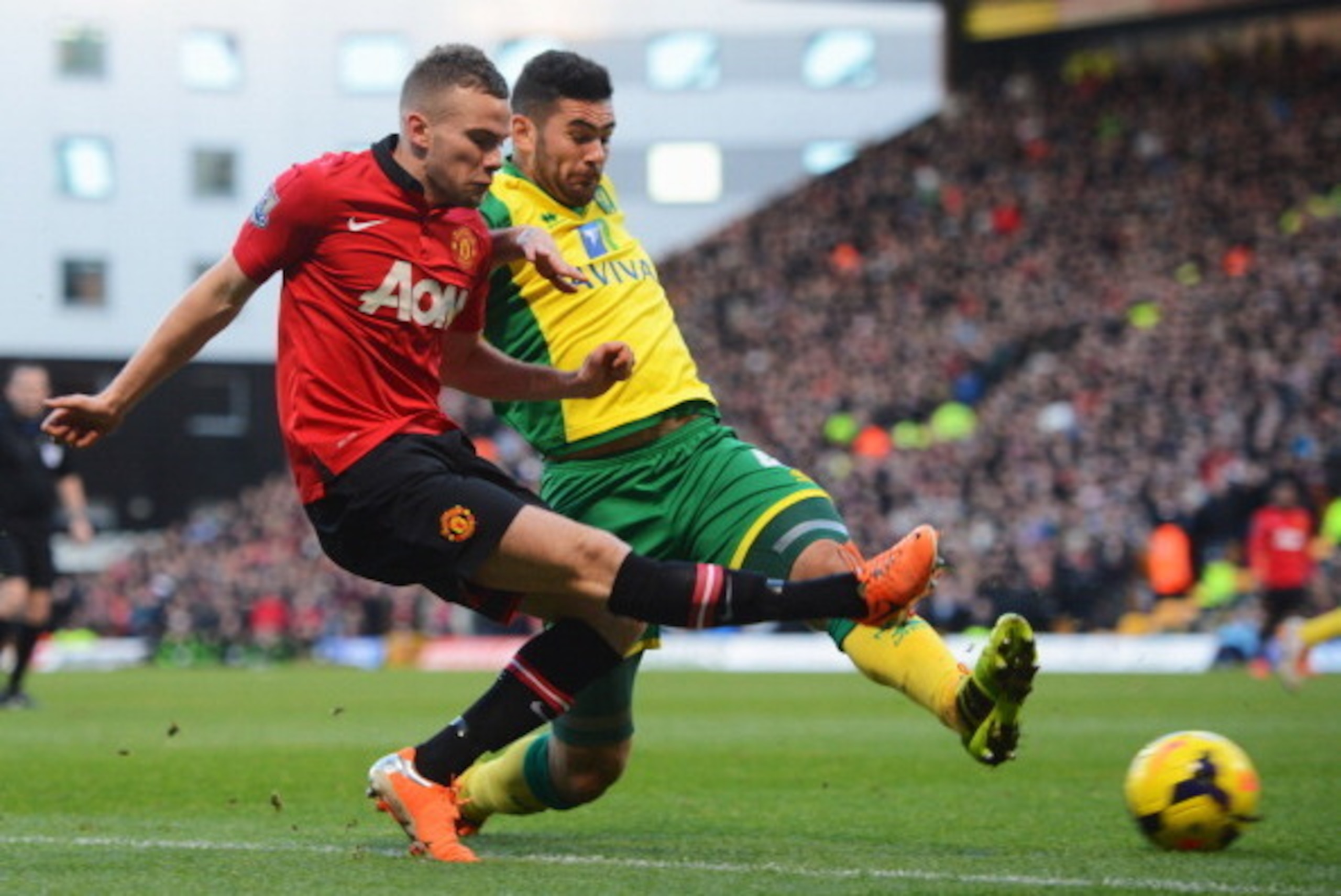 NORWICH, ENGLAND - DECEMBER 28:  Tom Cleverley of Manchester United is challenged by Bradley Johnson of Norwich City  during the Barclays Premier League match between Norwich City and  Manchester United at Carrow Road on December 28, 2013 in Norwich, Engl