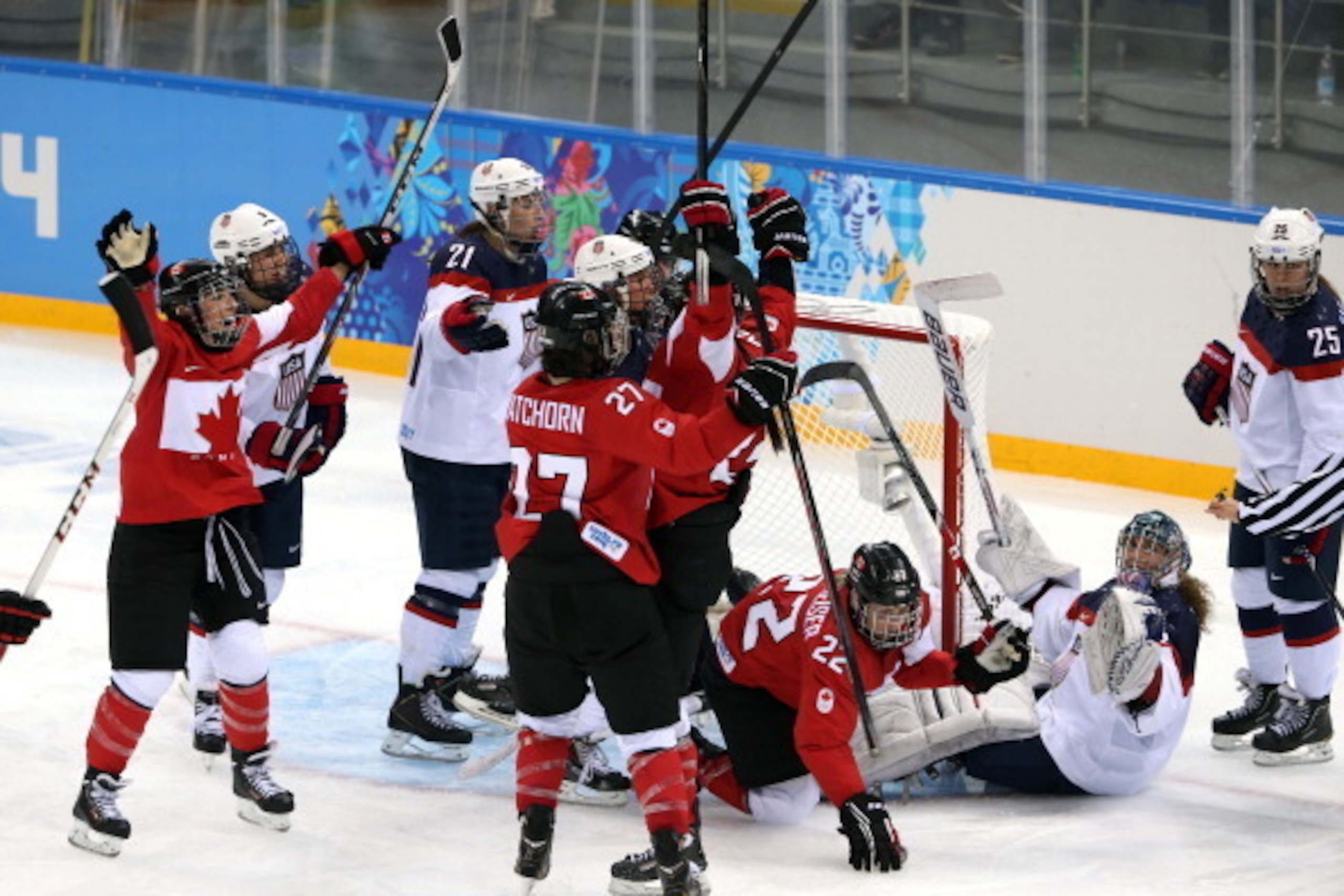 SOCHI, RUSSIA - FEBRUARY 12:  Hayley Wickenheiser #22 of Canada celebrates with teammates after scoring a goal in the third period against Jessie Vetter #31 the United States during the Women's Ice Hockey Preliminary Round Group A game on day five of the 