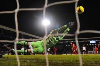 LONDON, ENGLAND - FEBRUARY 12:  David Stockdale of Fulham dives as Steven Gerrard of Liverpool scores their third goal from the penalty spot during the Barclays Premier League match between Fulham and Liverpool at Craven Cottage on February 12, 2014 in Lo