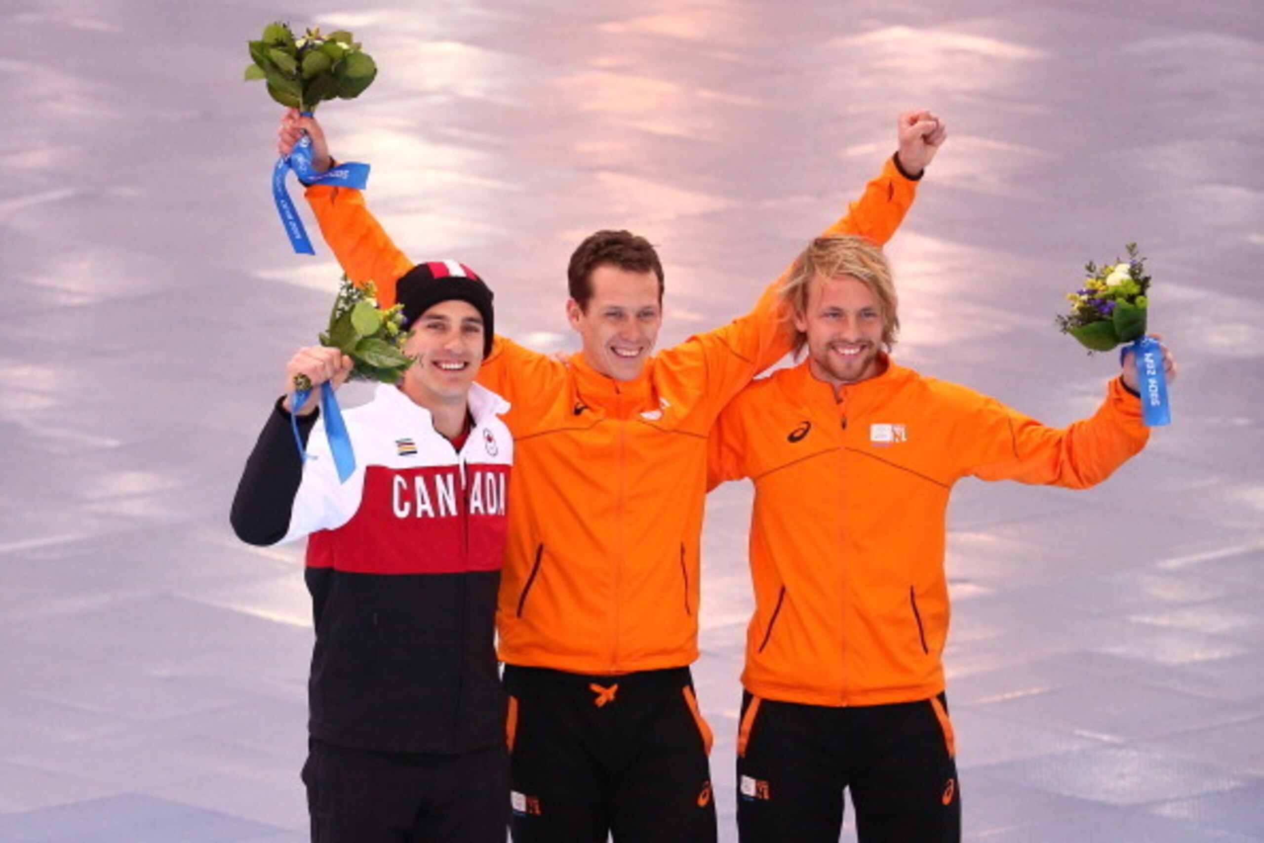 SOCHI, RUSSIA - FEBRUARY 12:  (L-R) Silver medalist Denny Morrison of Canada, gold medalist Stefan Groothuis of the Netherlands and bronze medalist Michel Mulder of the Netherlands celebrate during the flower ceremony for the  Men's 1000m Speed Skating ev