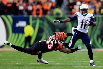 CINCINNATI, OH - JANUARY 05:  Wide receiver Eddie Royal #11 of the San Diego Chargers runs with the ball as defensive end Michael Johnson #93 of the Cincinnati Bengals defends during a Wild Card Playoff game at Paul Brown Stadium on January 5, 2014 in Cin