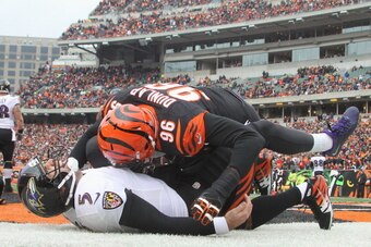 CINCINNATI, OH - DECEMBER 29:  Carlos Dunlap #96 of the Cincinnati Bengals slams Joe Flacco #5 of the Baltimore Ravens to the turf during their game at Paul Brown Stadium on December 29, 2013 in Cincinnati, Ohio.  The Bengals defeated the Ravens 34-17.  (