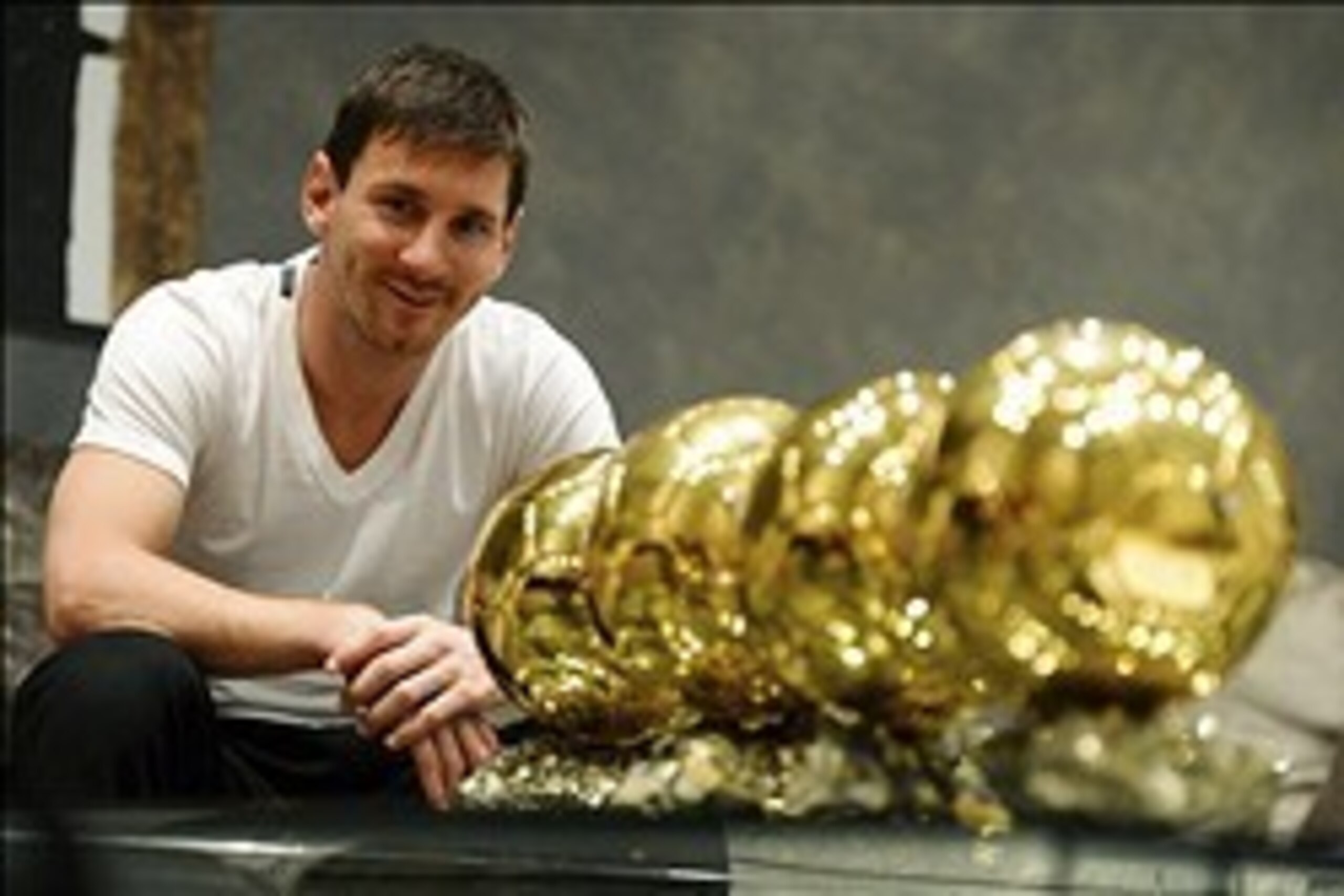 Jan 9, 2013; Barcelona, SPAIN; Lionel Messi poses with his four Ballon d'Or trophies aka golden ball trophies after winning the World Player accolade for a fourth straight year.  Mandatory Credit: Rondeau/Presse Sports via USA TODAY Sports