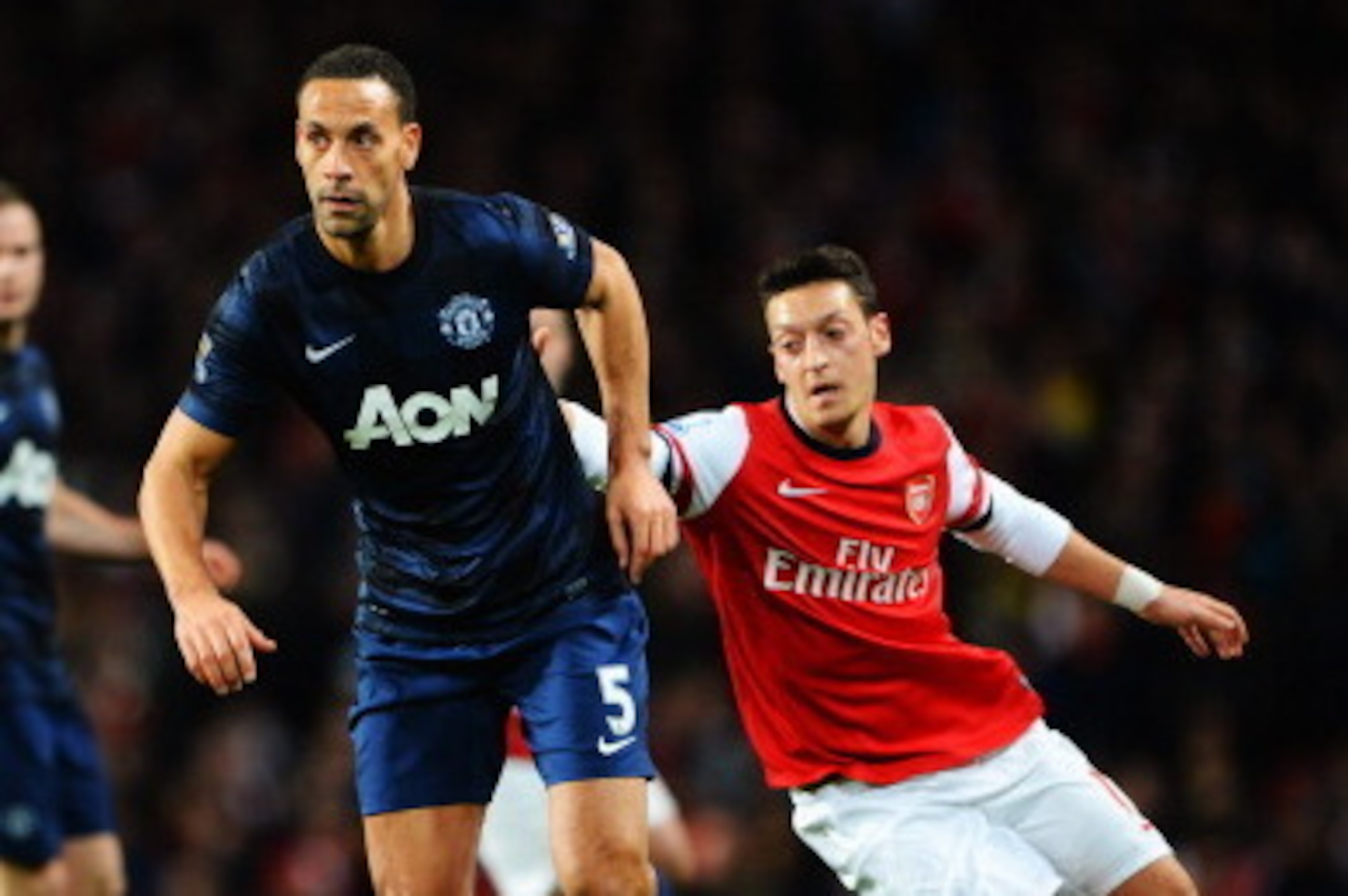 LONDON, ENGLAND - FEBRUARY 12:  Rio Ferdinand of Manchester United holds off the challenge of Mesut Ozil of Arsenal challenge for the ball during the Barclays Premier League match between Arsenal and Manchester United at the Emirates Stadium on February 1