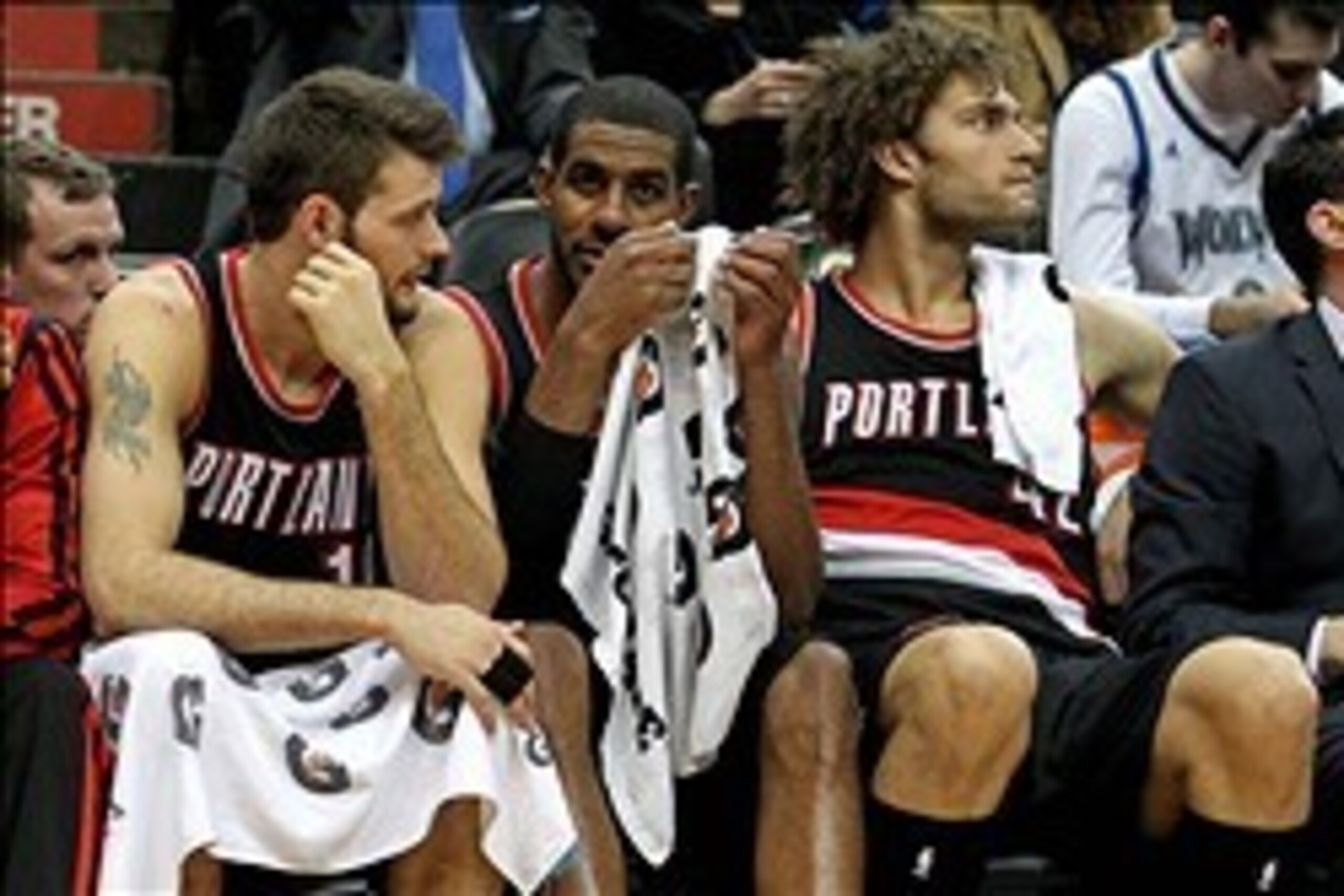 Dec 18, 2013; Minneapolis, MN, USA; Portland Trail Blazers center Joel Freeland (19), forward LaMarcus Aldridge (12) and center Robin Lopez (42) react on the bench during the fourth quarter against the Minnesota Timberwolves at Target Center. The Timberwo