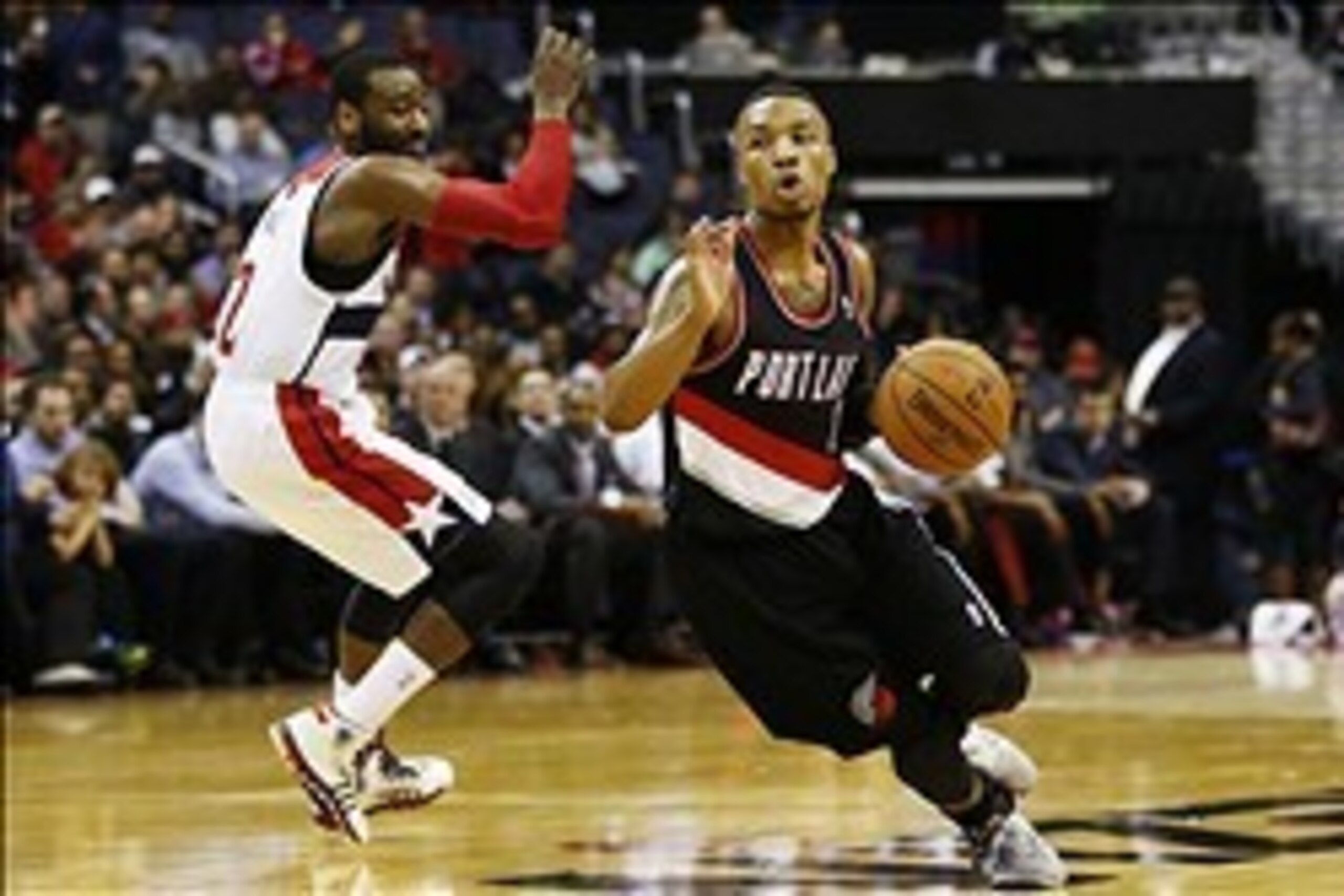 Feb 3, 2014; Washington, DC, USA; Portland Trail Blazers point guard Damian Lillard (0) dribbles the ball past Washington Wizards point guard John Wall (2) in the fourth quarter at Verizon Center. The Wizards won 100-90. Mandatory Credit: Geoff Burke-USA 