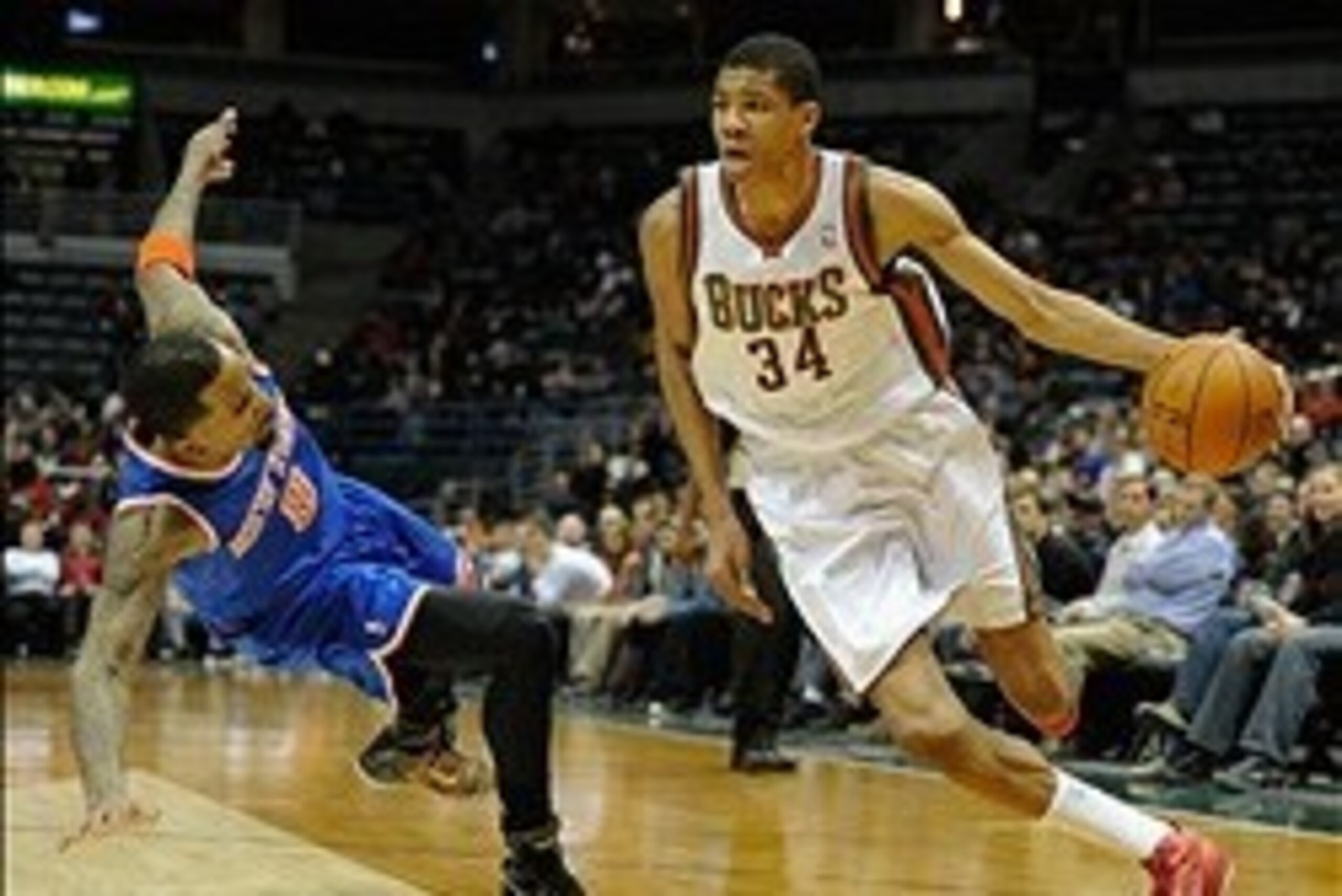 Feb 3, 2014; Milwaukee, WI, USA;  Milwaukee Bucks guard Giannis Antetokounmpo (34) drives past New York Knicks guard J.R. Smith (8) in the 4th quarter at BMO Harris Bradley Center. Mandatory Credit: Benny Sieu-USA TODAY Sports