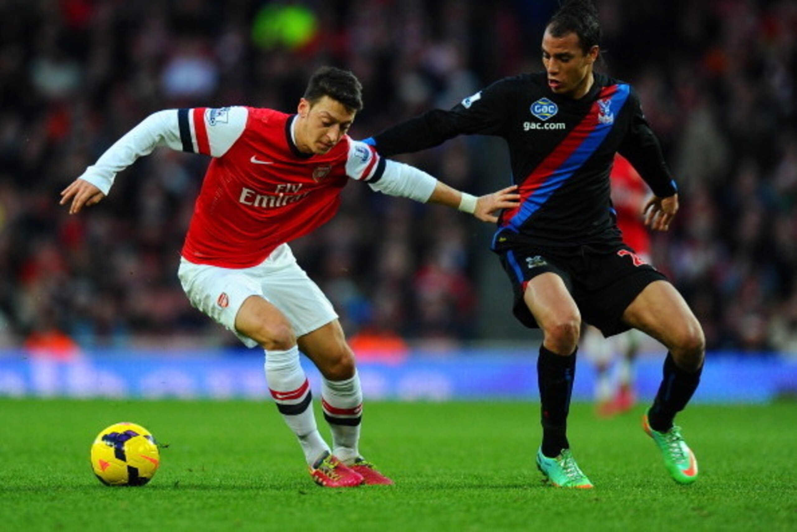 LONDON, ENGLAND - FEBRUARY 02:  Marouane Chamakh of Crystal Palace marshalls Mesut Oezil of Arsenal during the Barclays Premier League match between Arsenal and Crystal Palace at Emirates Stadium on February 2, 2014 in London, England.  (Photo by Mike Hew