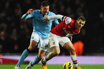 LONDON, ENGLAND - JANUARY 13:  Jack Wilshere of Arsenal holds off Javi Garcia of Manchester City during the Barclays Premier League match between Arsenal and Manchester City at Emirates Stadium on January 13, 2013 in London, England.  (Photo by Mike Hewit