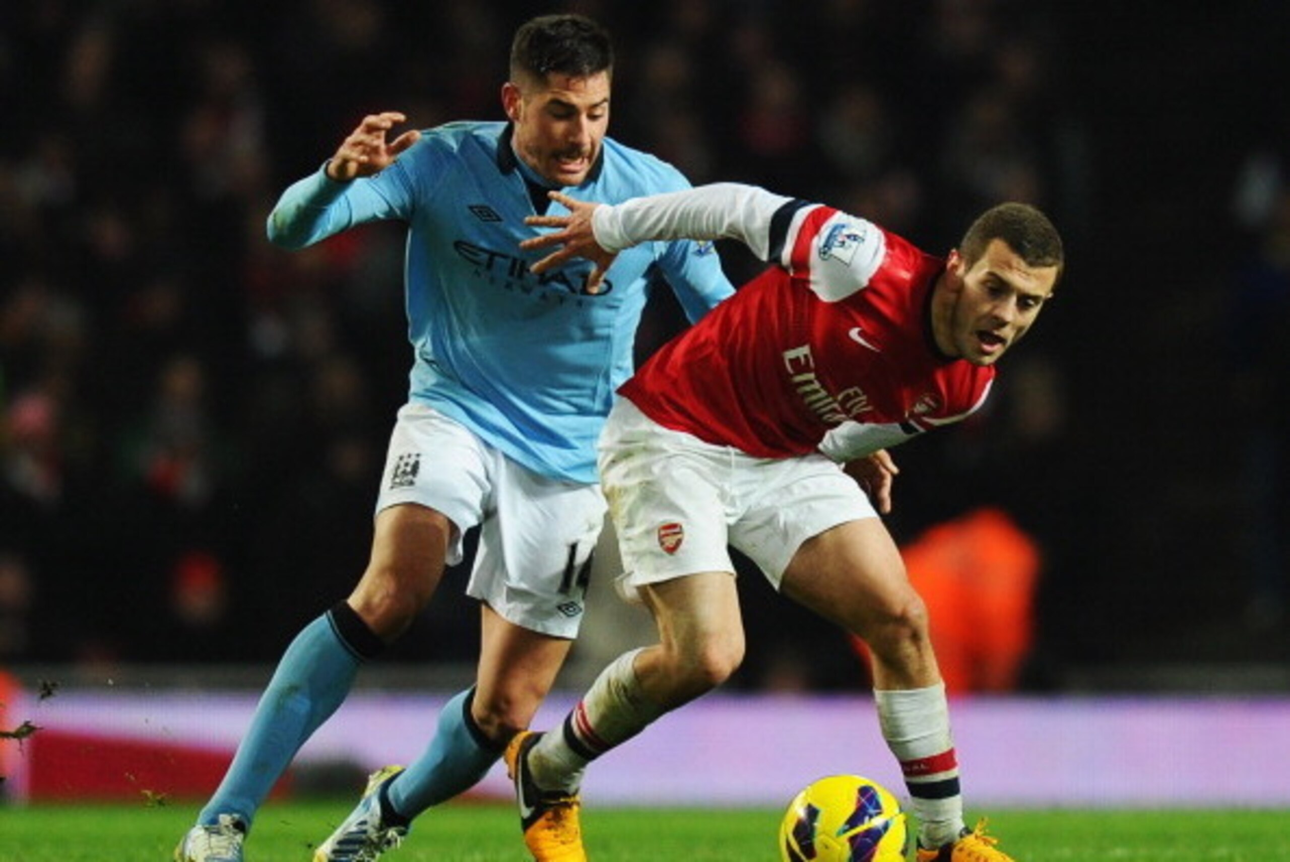 LONDON, ENGLAND - JANUARY 13:  Jack Wilshere of Arsenal holds off Javi Garcia of Manchester City during the Barclays Premier League match between Arsenal and Manchester City at Emirates Stadium on January 13, 2013 in London, England.  (Photo by Mike Hewit