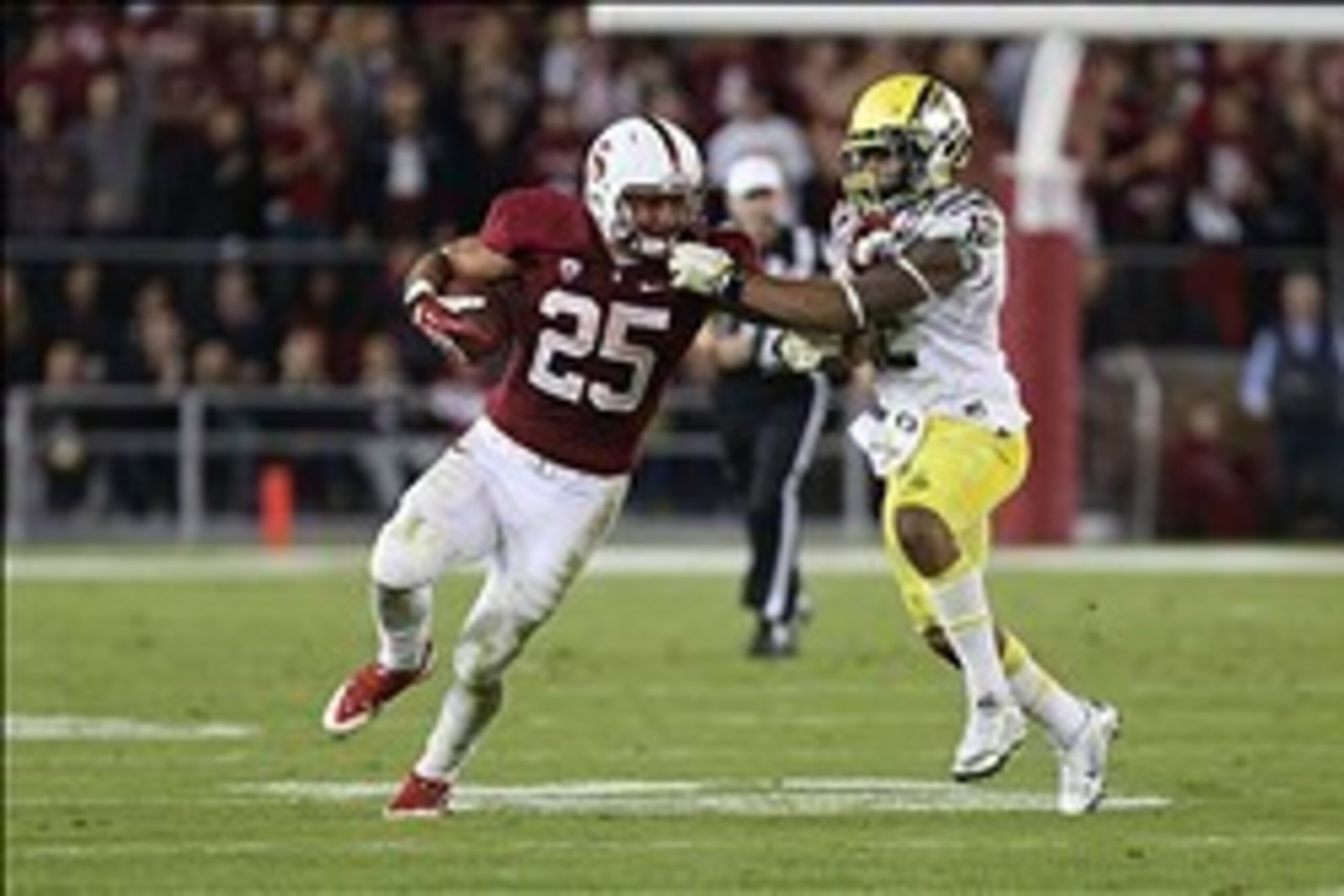 Nov 7, 2013; Stanford, CA, USA; Oregon Ducks safety Brian Jackson (12) grabs the facemask of Stanford Cardinal running back Tyler Gaffney (25) during the third quarter at Stanford Stadium. The Stanford Cardinal defeated the Oregon Ducks 26-20. Mandatory C