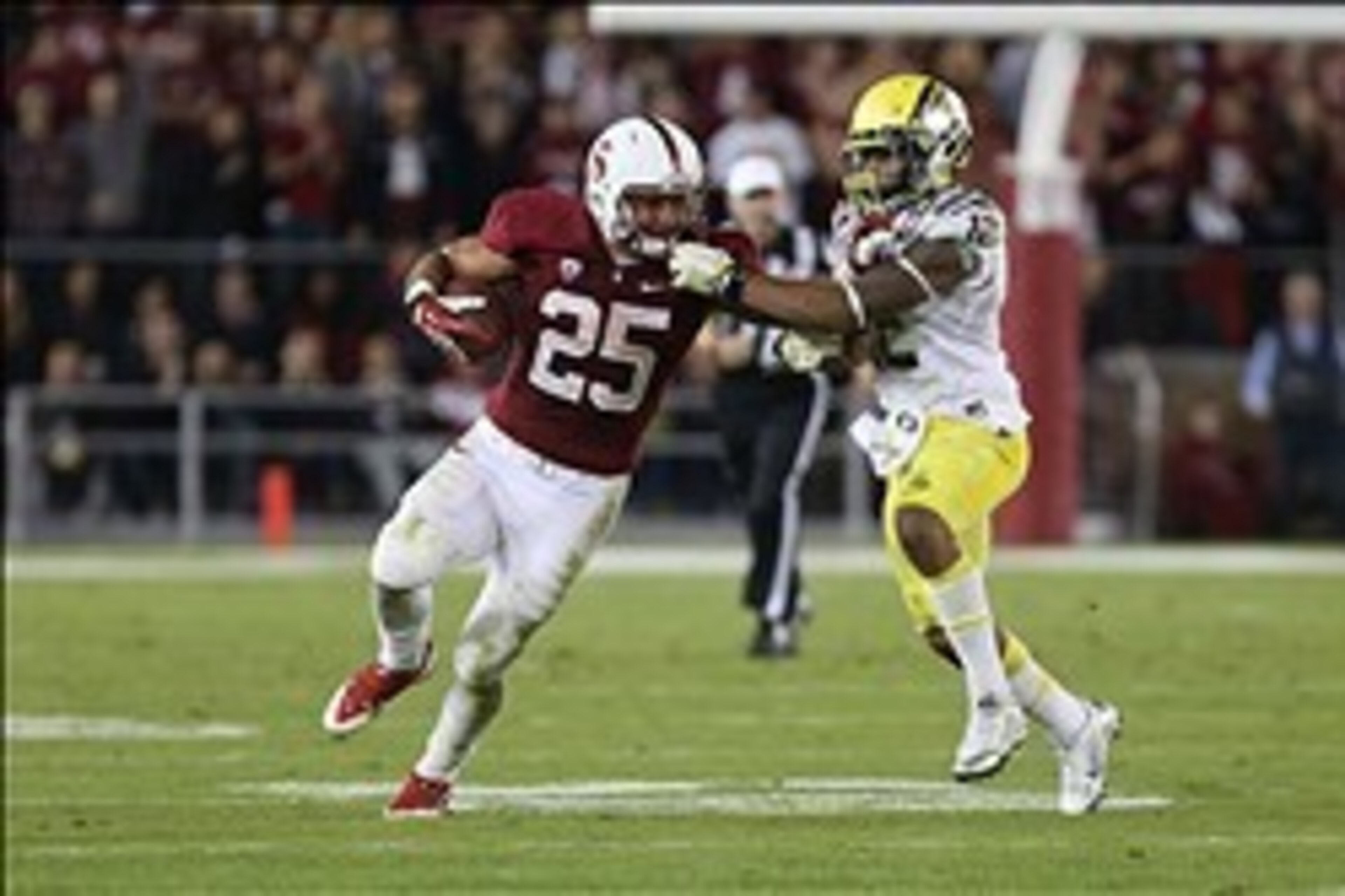 Nov 7, 2013; Stanford, CA, USA; Oregon Ducks safety Brian Jackson (12) grabs the facemask of Stanford Cardinal running back Tyler Gaffney (25) during the third quarter at Stanford Stadium. The Stanford Cardinal defeated the Oregon Ducks 26-20. Mandatory C
