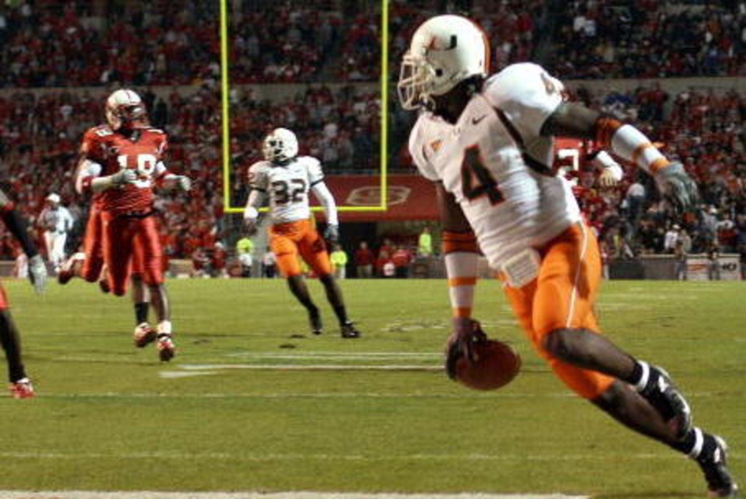 RALEIGH, NC - OCTOBER 23: Devin Hester #4 of the Miami Hurricanes looks back after returning the opening kickoff 100 yards for a touchdown against the North Carolina State Wolfpack during an Atlantic Coast Conference game October 23, 2004, at Carter-Finle RALEIGH, NC - OCTOBER 23: Devin Hester #4 of the Miami Hurricanes looks back after returning the opening kickoff 100 yards for a touchdown against the North Carolina State Wolfpack during an Atlantic Coast Conference game October 23, 2004, at Carter-Finle