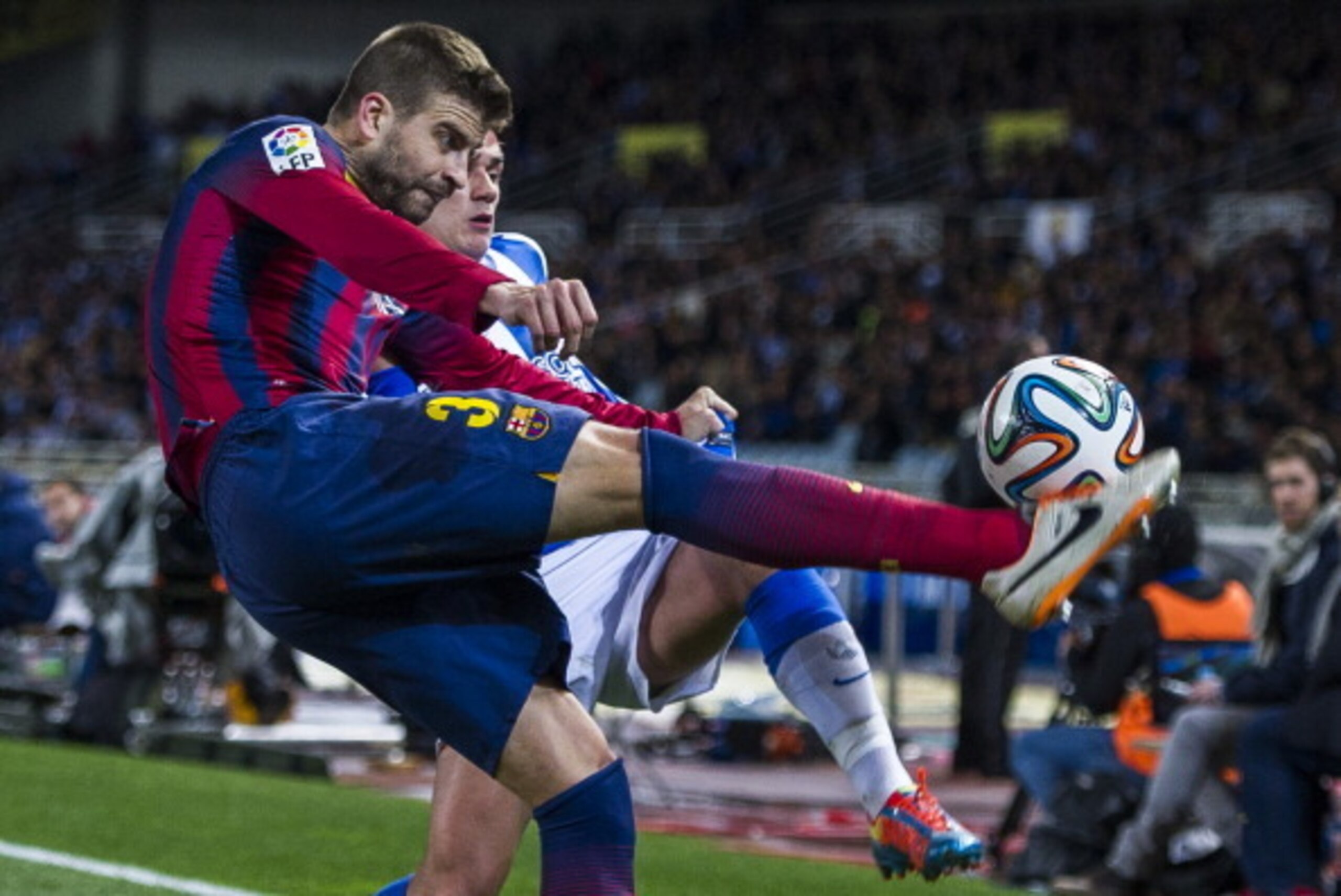 SAN SEBASTIAN, SPAIN - FEBRUARY 12:  Gerard Pique of FC Barcelona duels for the ball with Antoine Griezmann of Real Sociedad during the Copa del Rey Semi-Final first leg match between Real Sociedad and Barcelona at Estadio Anoeta  on February 12, 2014 in 