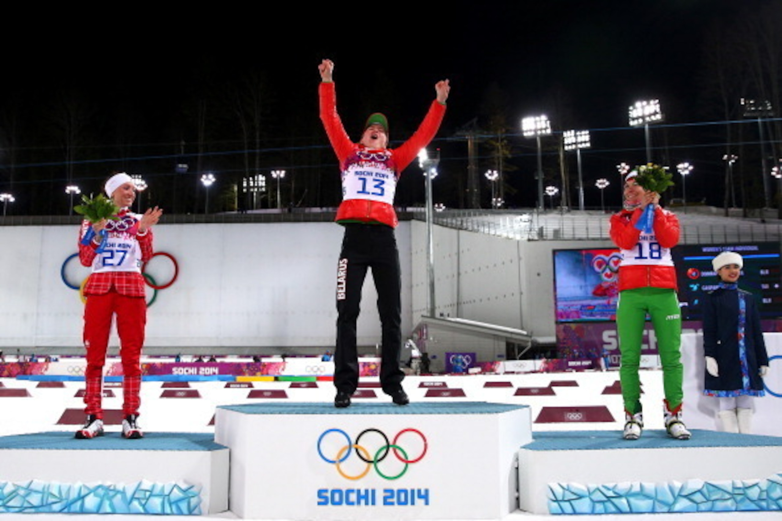 SOCHI, RUSSIA - FEBRUARY 14:  (L-R) Silver medalist Selina Gasparin of Switzerland, gold medalist Darya Domracheva of Belarus and bronze medalist Nadezhda Skardino of Belarus celebrate on the podium during the flower ceremony for the Women's 15 km Individ
