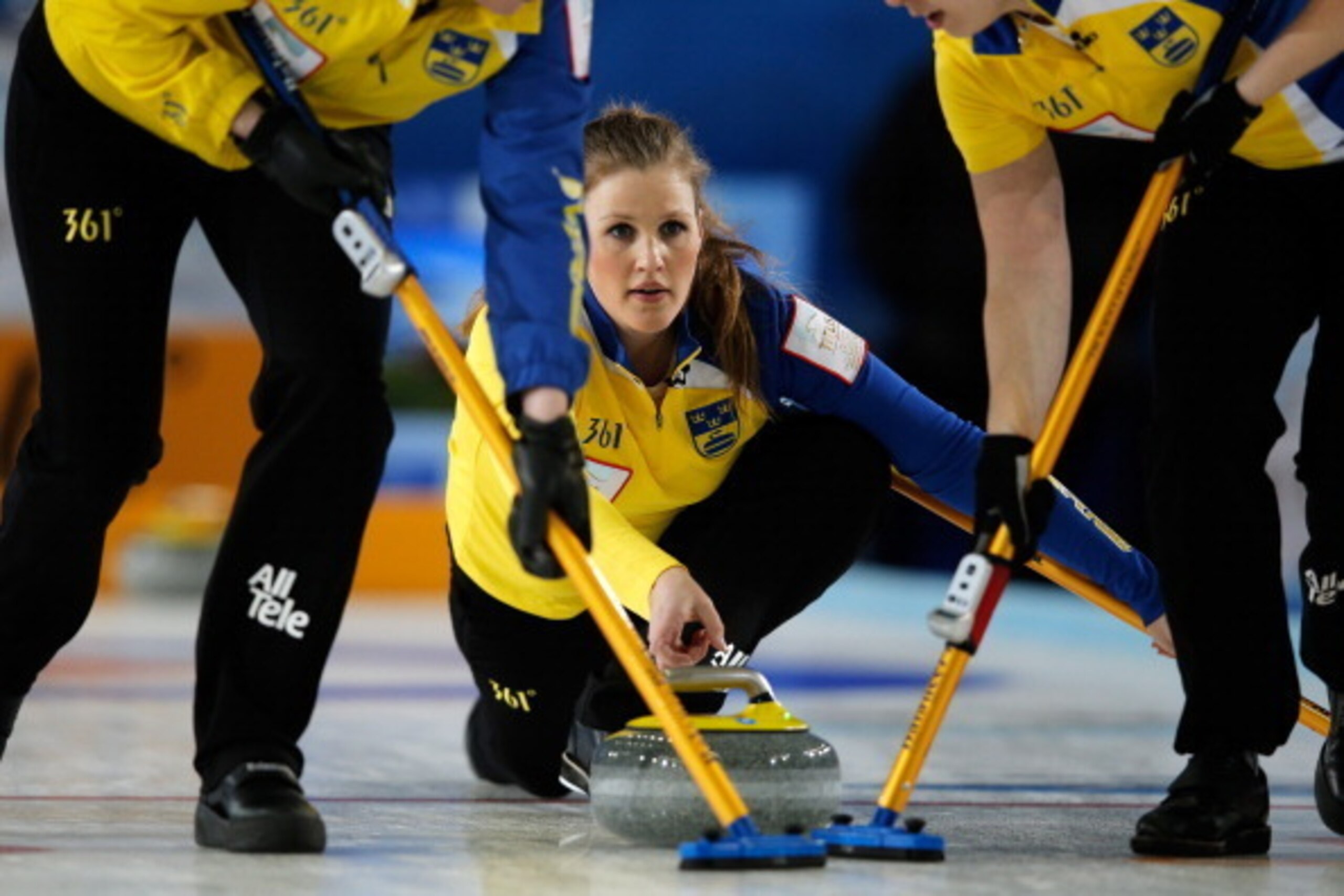 RIGA, LATVIA - MARCH 24:  Christina Bertrup (C) of Sweden throws a stone as Maria Prytz (L) and Maria Wennerstrom (R) sweep during the Gold Medal match between Scotland and Sweden on Day 9 of the Titlis Glacier Mountain World Women's Curling Championship 