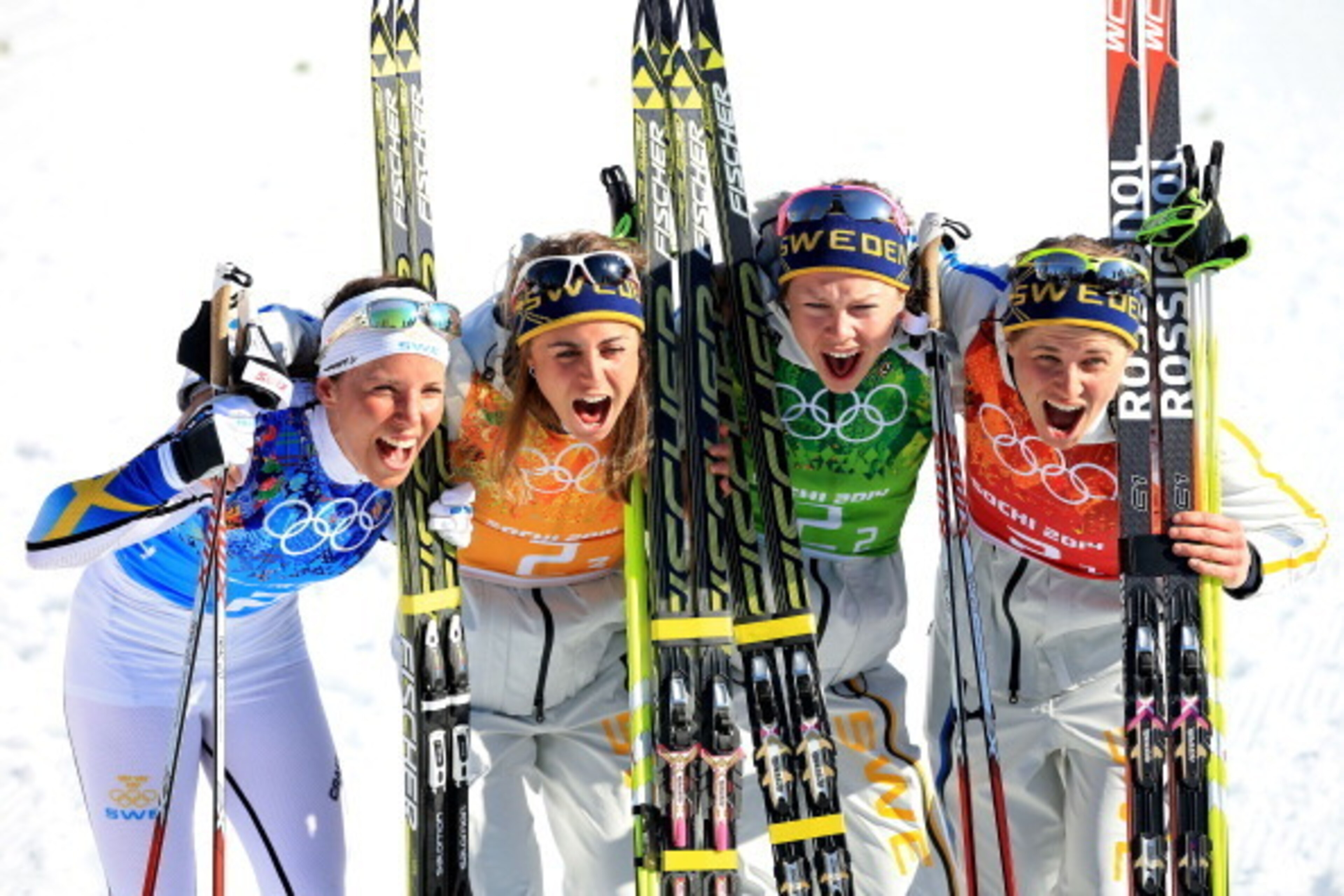 SOCHI, RUSSIA - FEBRUARY 15:  (L to R) Charlotte Kalla, Anna Haag, Emma Wiken and Ida Ingemarsdotter of Sweden celebrate winning the gold medal in the Women's 4 x 5 km Relay during day eight of the Sochi 2014 Winter Olympics at Laura Cross-country Ski & B