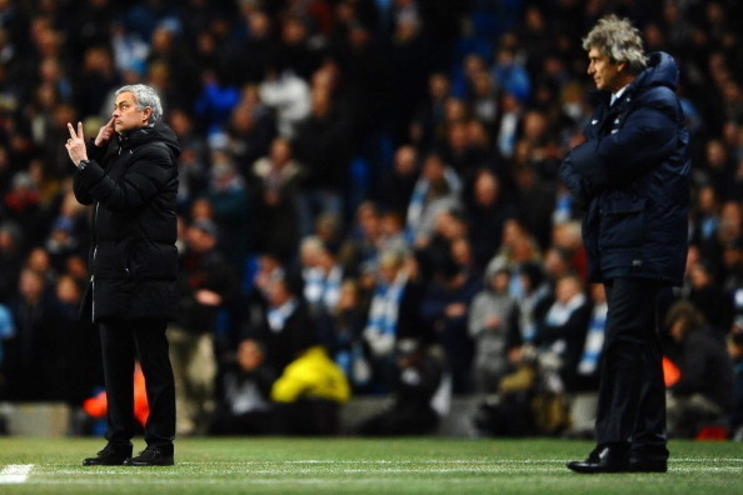 MANCHESTER, ENGLAND - FEBRUARY 03:  Manuel Pellegrini manager of Manchester City looks on as  Jose Mourinho manager of Chelsea give instructions during the Barclays Premier League match between Manchester City and Chelsea at Etihad Stadium on February 3, 