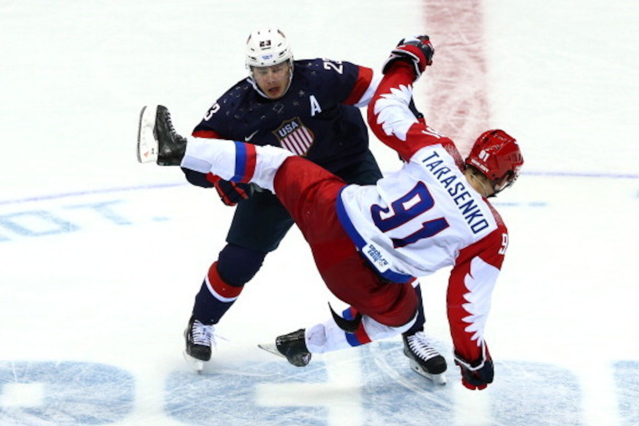 SOCHI, RUSSIA - FEBRUARY 15:  Dustin Brown #23 of the United States collides wih Vladimir Tarasenko #91 of Russia during the Men's Ice Hockey Preliminary Round Group A game on day eight of the Sochi 2014 Winter Olympics at Bolshoy Ice Dome on February 15,