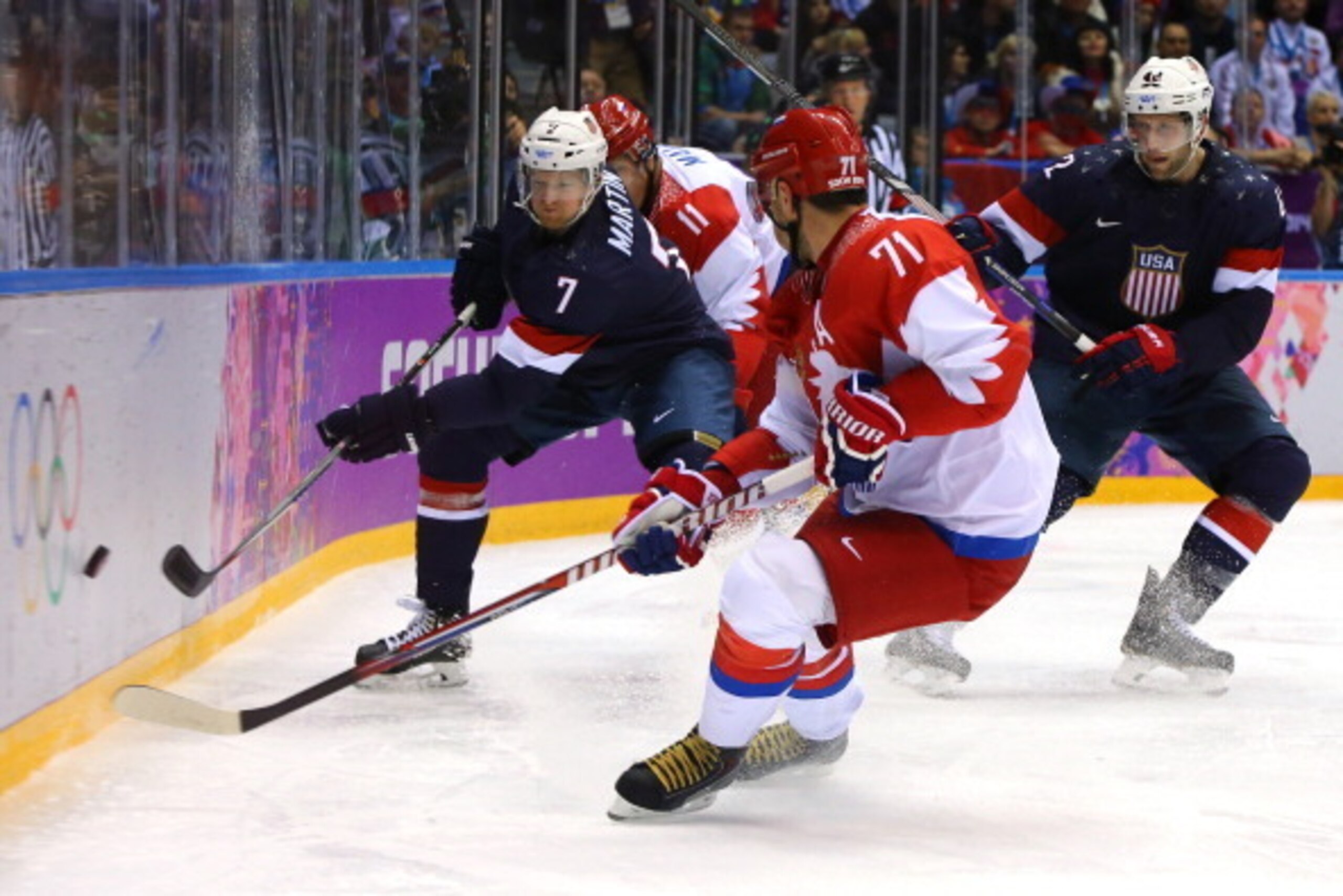 SOCHI, RUSSIA - FEBRUARY 15:  Paul Martin #7 of the United States shoots the puck against Ilya Kovalchuk #71 of Russia during the Men's Ice Hockey Preliminary Round Group A game on day eight of the Sochi 2014 Winter Olympics at Bolshoy Ice Dome on Februar