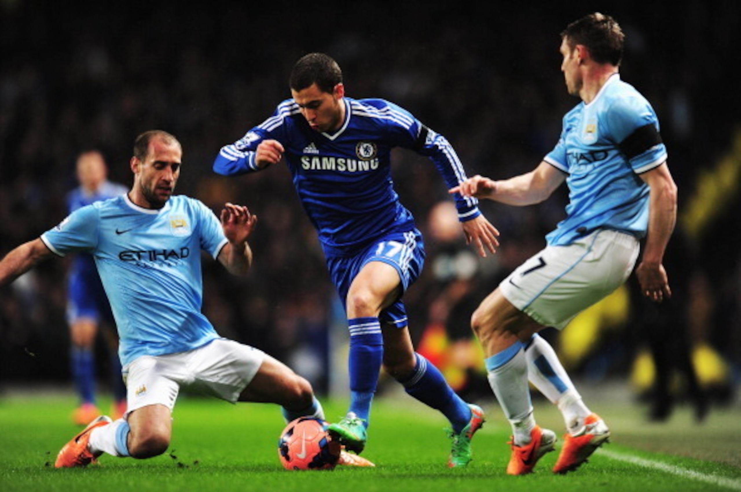 MANCHESTER, ENGLAND - FEBRUARY 15:  Eden Hazard (C) of Chelsea holds off the challenge of Pablo Zabaleta (L) and James Milner (R) of Manchester City during the FA Cup Fifth Round match between Manchester City and Chelsea at the Etihad Stadium on February 