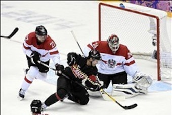 Feb 14, 2014; Sochi, RUSSIA; Austria goalie Mathias Lange (24) and Austria defenseman Thomas Pock (22) defend the net against Canada forward Martin St. Louis (26) in a men's preliminary round ice hockey game during the Sochi 2014 Olympic Winter Games at B