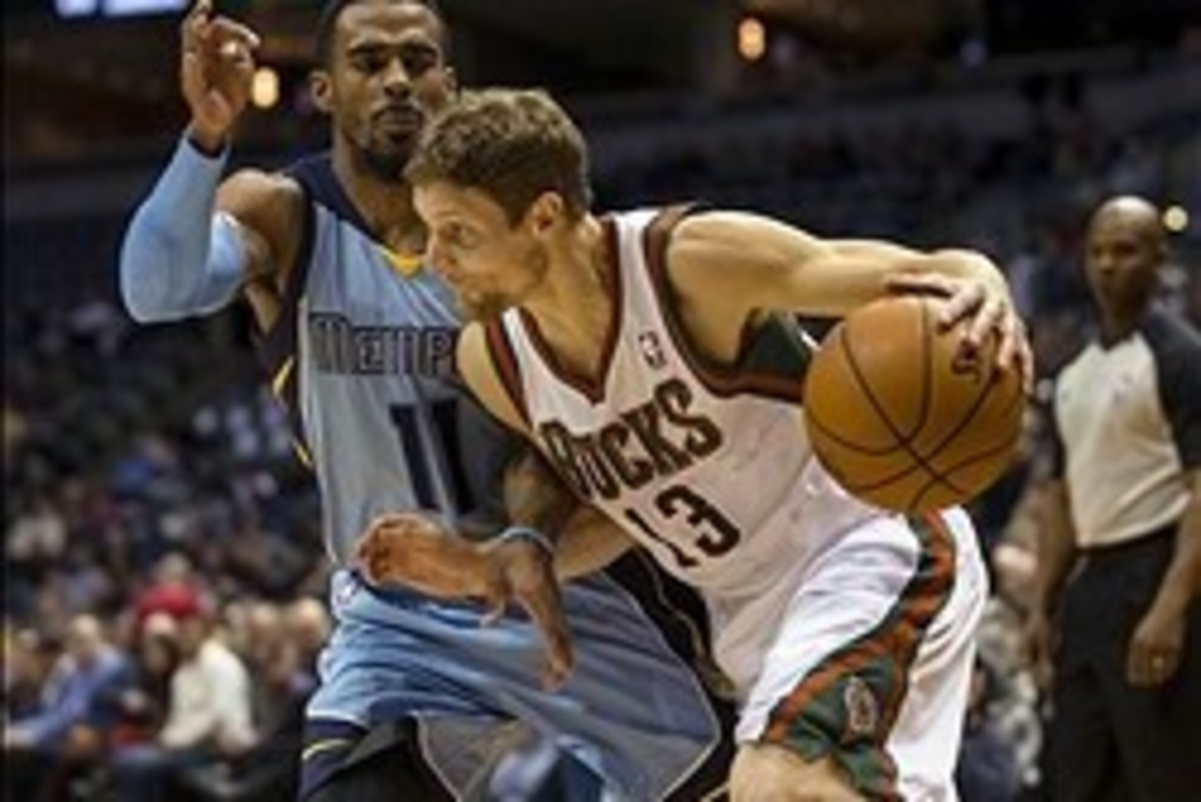 Jan 15, 2014; Milwaukee, WI, USA;  Milwaukee Bucks guard Luke Ridnour (13) drives for the basket as Memphis Grizzlies guard Mike Conley (11) defends during the third quarter at BMO Harris Bradley Center. Mandatory Credit: Jeff Hanisch-USA TODAY Sports