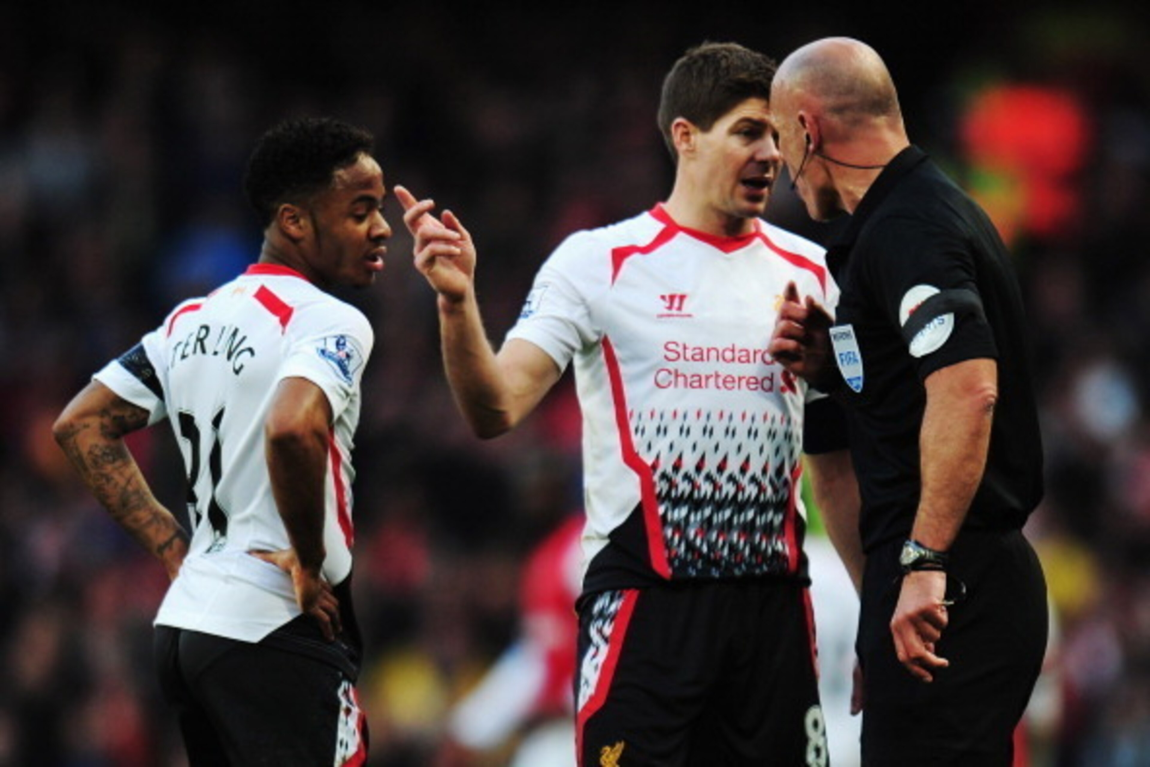 LONDON, ENGLAND - FEBRUARY 16: Raheem Sterling (L) and Steven Gerrard (C) of Liverpool talk with match referee Howard Webb during the FA Cup Fifth Round match between Arsenal and Liverpool at the Emirates Stadium on February 16, 2014 in London, England. LONDON, ENGLAND - FEBRUARY 16: Raheem Sterling (L) and Steven Gerrard (C) of Liverpool talk with match referee Howard Webb during the FA Cup Fifth Round match between Arsenal and Liverpool at the Emirates Stadium on February 16, 2014 in London, England.