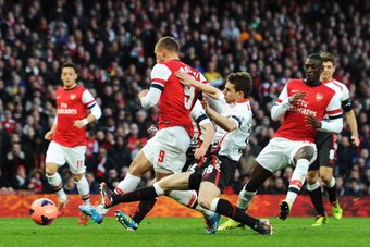 LONDON, ENGLAND - FEBRUARY 16:  Lukas Podolski (C) of Arsenal gets his shot in under pressure to score his sides second goal during the FA Cup Fifth Round match between Arsenal and Liverpool at the Emirates Stadium on February 16, 2014 in London, England.