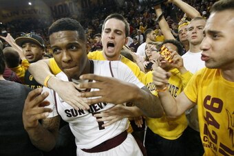 TEMPE, AZ - FEBRUARY 14: Jahii Carson #1 of the Arizona State Sun Devils is embraced by students in celebration of a 69-66 double overtime victory over the Arizona Wildcats during a college basketball game at Wells Fargo Arena on February 14, 2014 in Tem TEMPE, AZ - FEBRUARY 14: Jahii Carson #1 of the Arizona State Sun Devils is embraced by students in celebration of a 69-66 double overtime victory over the Arizona Wildcats during a college basketball game at Wells Fargo Arena on February 14, 2014 in Tem