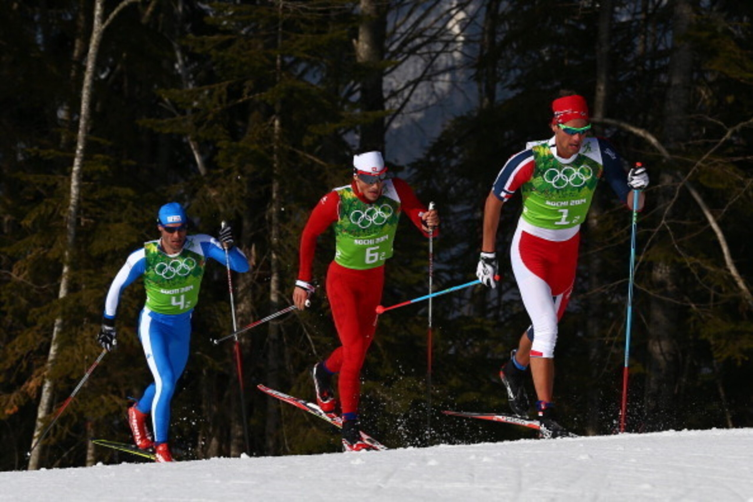 SOCHI, RUSSIA - FEBRUARY 16:  (R-L) Chris Andre Jespersen of Norway, Jonas Baumann of Switzerland and Giorgio di Centa of Italy compete in the Men's 4 x 10 km Relay during day nine of the Sochi 2014 Winter Olympics at Laura Cross-country Ski & Biathlon Ce