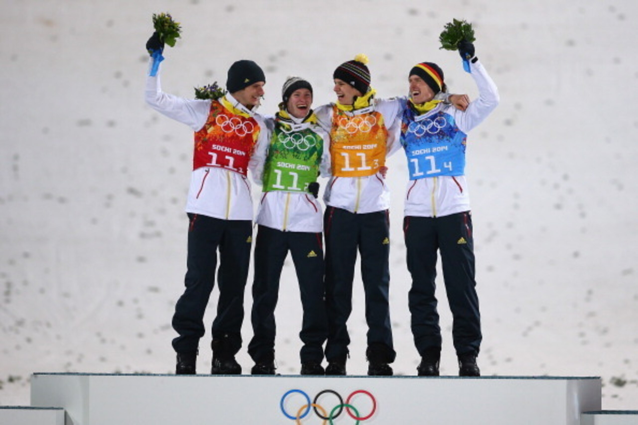 SOCHI, RUSSIA - FEBRUARY 17:  (L-R) Gold medalists Andreas Wank, Marinus Kraus, Andreas Wellinger and Severin Freund of Germany celebrate during the flower ceremony for the  Men's Team Ski Jumping final round on day 10 of the Sochi 2014 Winter Olympics at