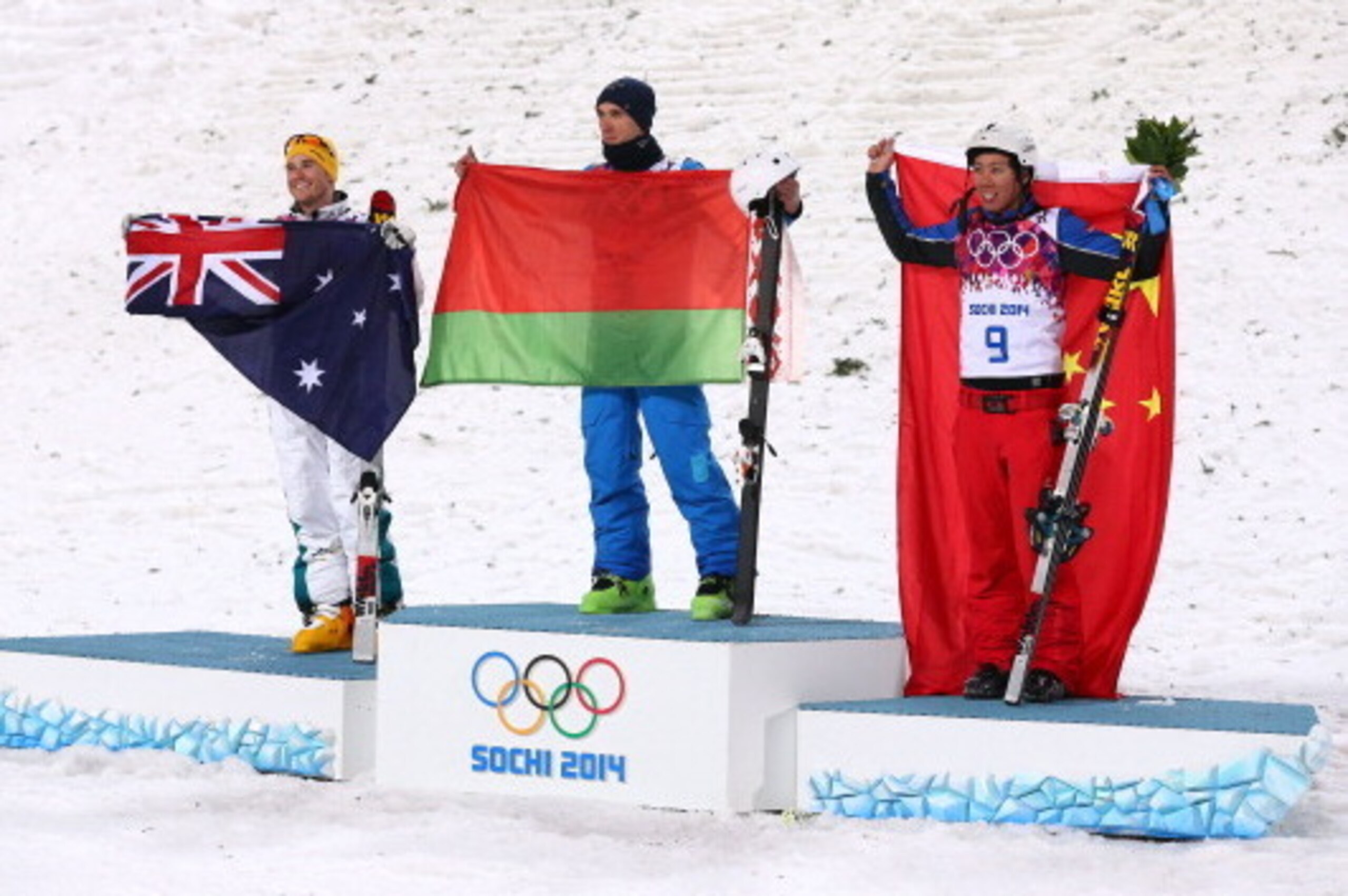 SOCHI, RUSSIA - FEBRUARY 17:  (L-R) Silver medalist David Morris of Australia, gold medalist Anton Kushnir of Belarus and bronze medalist Jia Zongyang of China celebrate on the podium during the flower ceremony for the Freestyle Skiing Men's Aerials Final