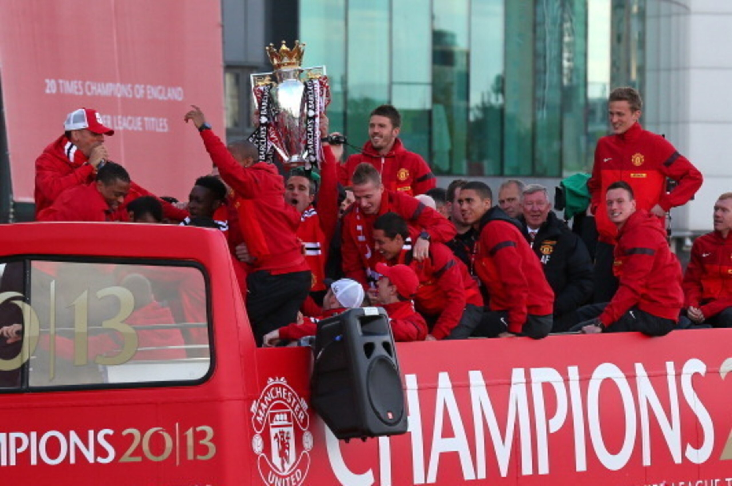 MANCHESTER, ENGLAND - MAY 13:  Robin Van Persie of Manchester United lifts the Premier League trophy as Sir Alex Ferguson and his team mates look on outside Old Trafford during the Manchester United Premier League Winners Parade on May 13, 2013 in Manches