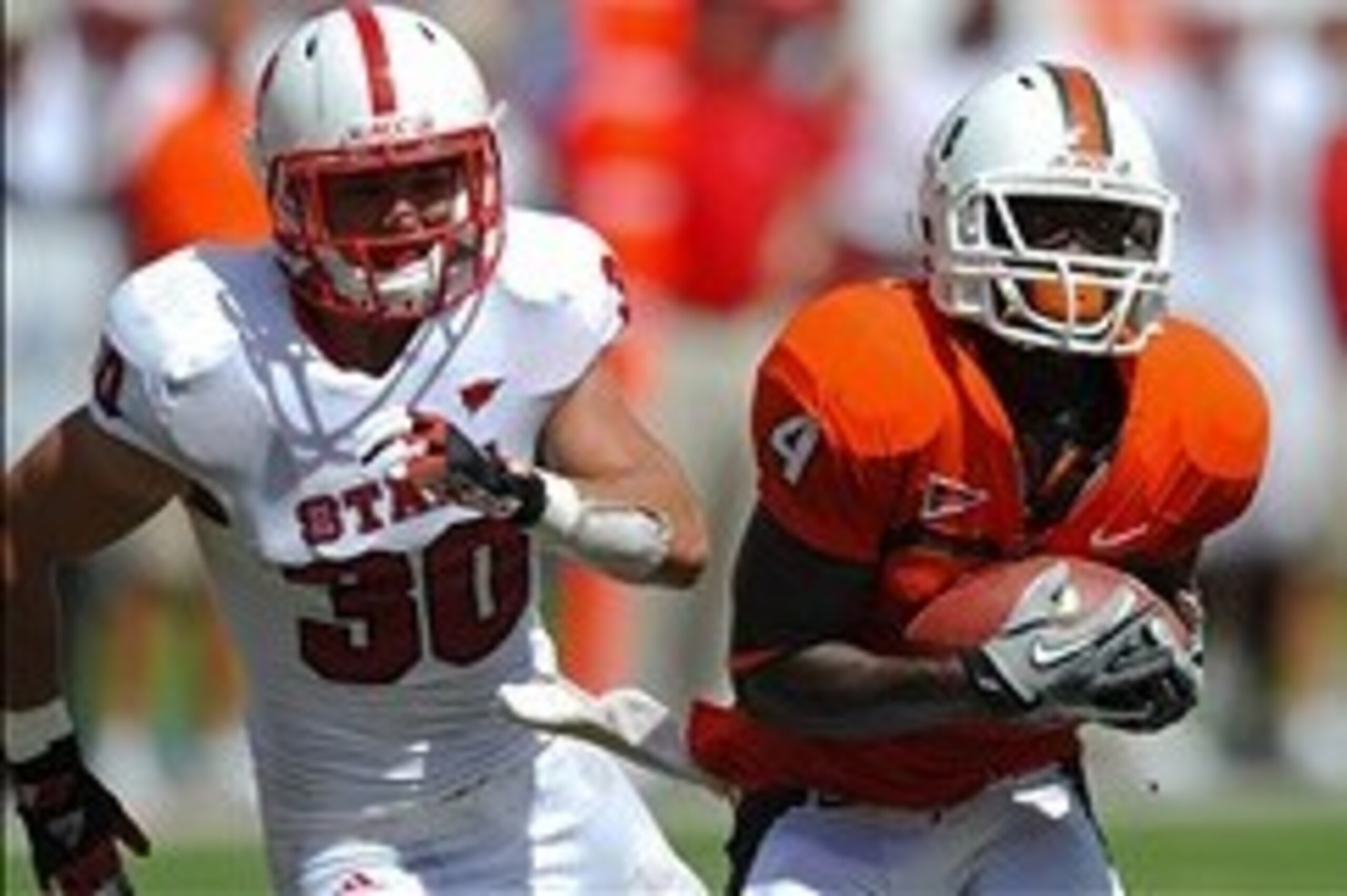 Sept 29, 2012; Miami, FL, USA; Miami Hurricanes wide receiver Phillip Dorsett (4) hauls in a catch in front of North Carolina State Wolfpack safety Brandan Bishop (30) during their game at Sun Life Stadium. Miami won 44-37. Mandatory Credit: Steve Mitchel