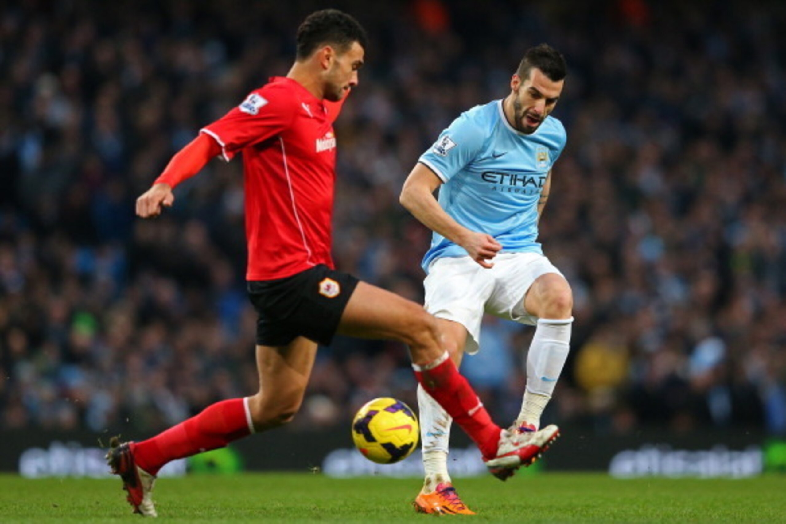 MANCHESTER, ENGLAND - JANUARY 18: Alvaro Negredo of Manchester City passes the ball through the legs off Steven Caulker of Cardiff during the Barclays Premier League match between Manchester City and Cardiff City at the Etihad Stadium on January 18, 2014 MANCHESTER, ENGLAND - JANUARY 18: Alvaro Negredo of Manchester City passes the ball through the legs off Steven Caulker of Cardiff during the Barclays Premier League match between Manchester City and Cardiff City at the Etihad Stadium on January 18, 2014