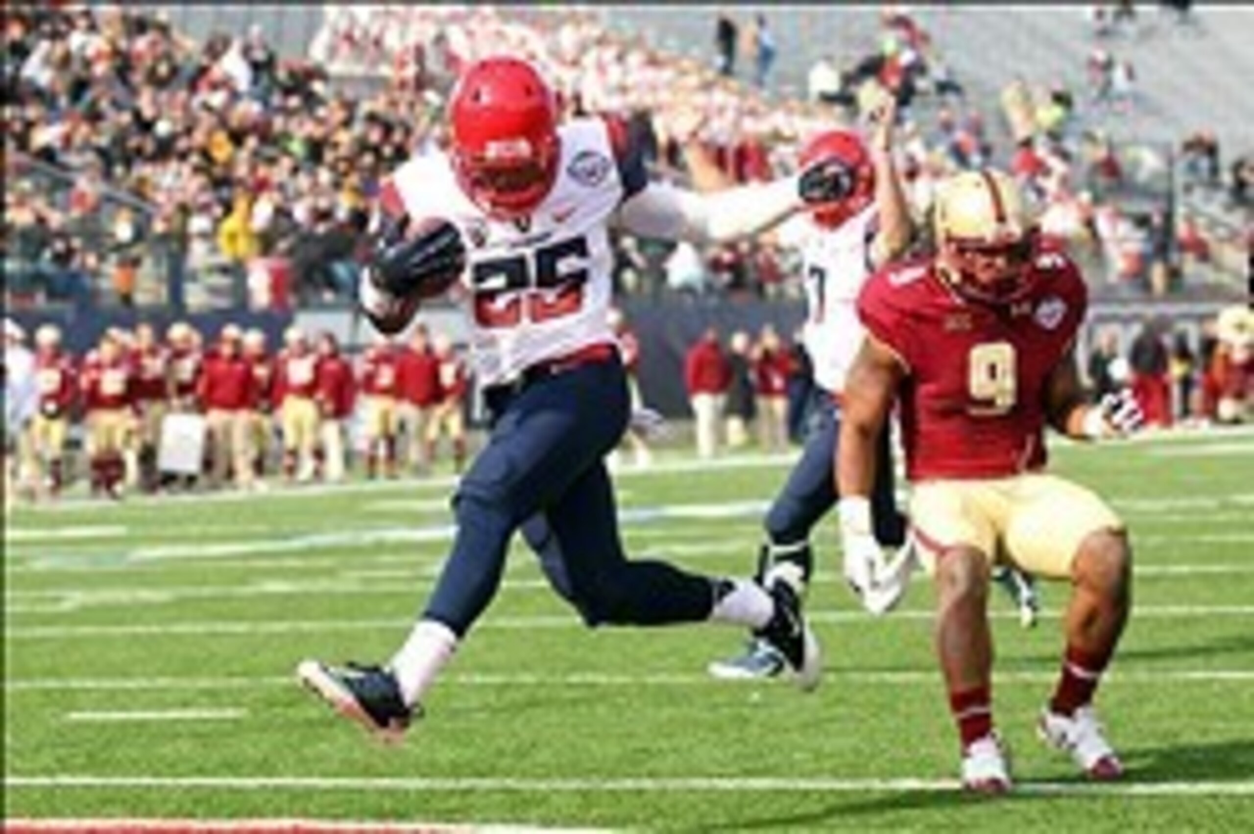 Dec 31, 2013; Shreveport, LA, USA; Arizona Wildcats running back Ka'Deem Carey (25) carries the ball into the end zone for a touchdown in front of Boston College Eagles defensive back Dominique Williams (9) in the third quarter at Independence Stadium. Ar