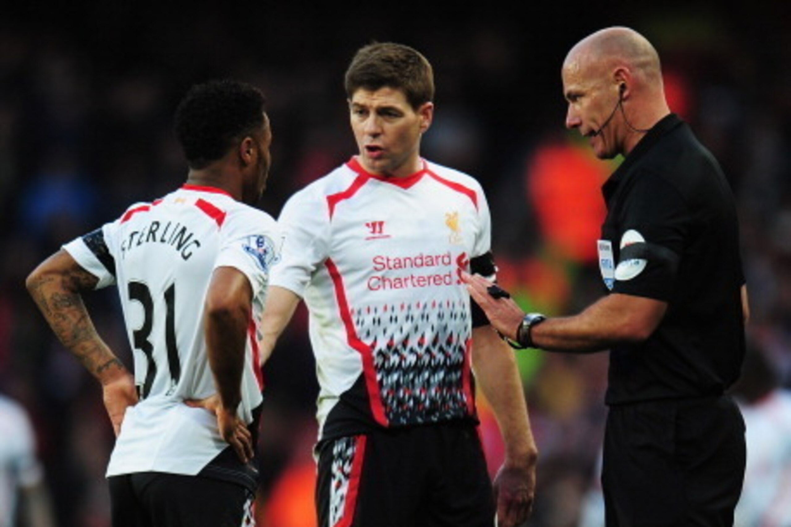 LONDON, ENGLAND - FEBRUARY 16:  Raheem Sterling (L) and Steven Gerrard (C) of Liverpool talk with match referee Howard Webb during the FA Cup Fifth Round match between Arsenal and Liverpool at the Emirates Stadium on February 16, 2014 in London, England. 