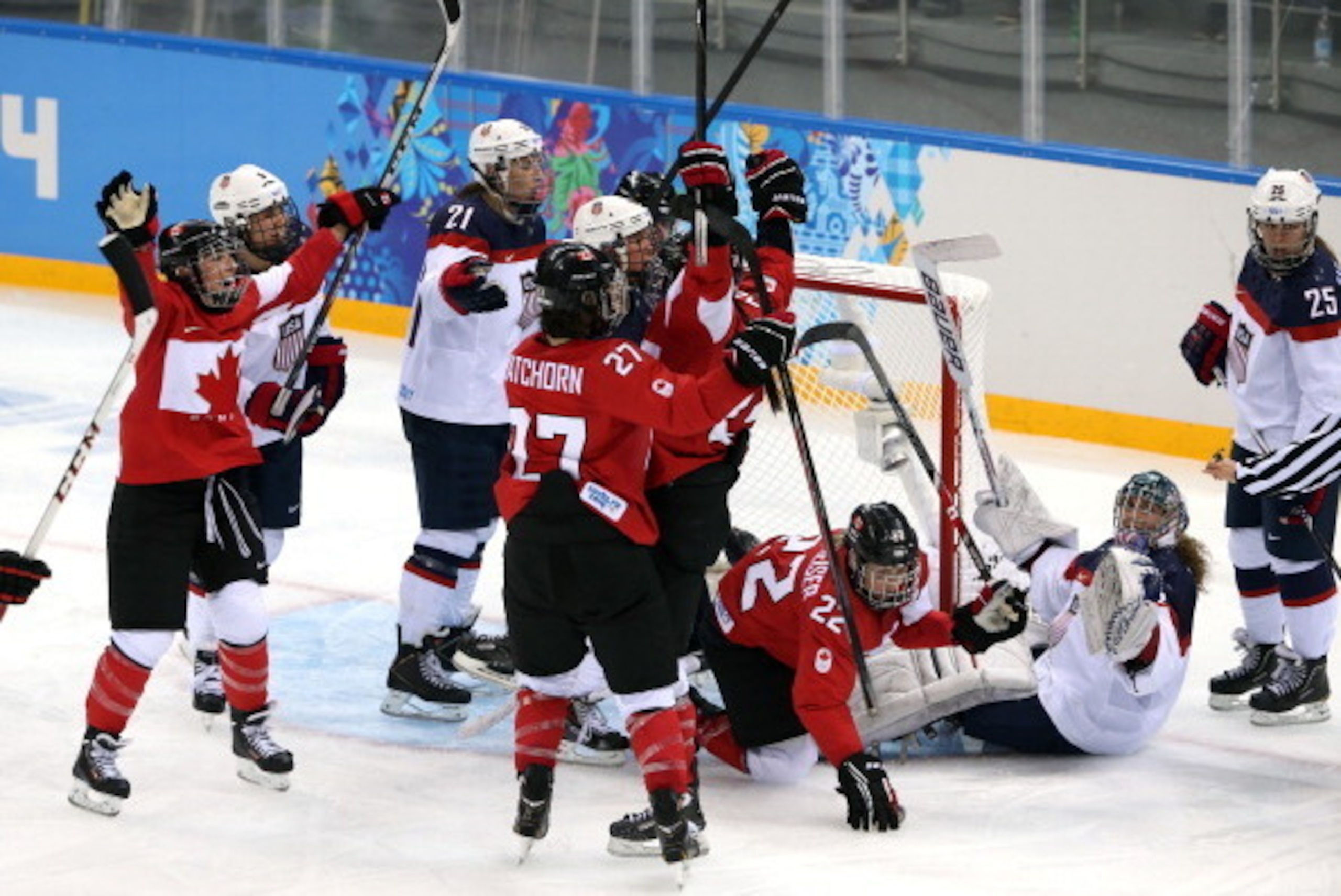 SOCHI, RUSSIA - FEBRUARY 12:  Hayley Wickenheiser #22 of Canada celebrates with teammates after scoring a goal in the third period against Jessie Vetter #31 the United States during the Women's Ice Hockey Preliminary Round Group A game on day five of the 