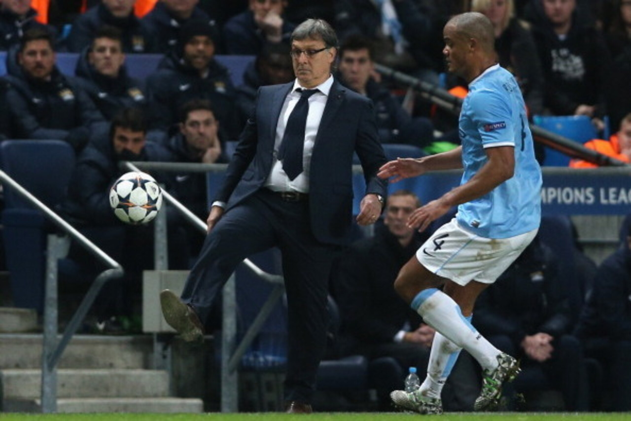 MANCHESTER, ENGLAND - FEBRUARY 18:  Barcelona Head Coach Gerardo Martino beats Vincent Kompany of Manchester City to the ball during the UEFA Champions League Round of 16 first leg match between Manchester City and Barcelona at the Etihad Stadium on Febru