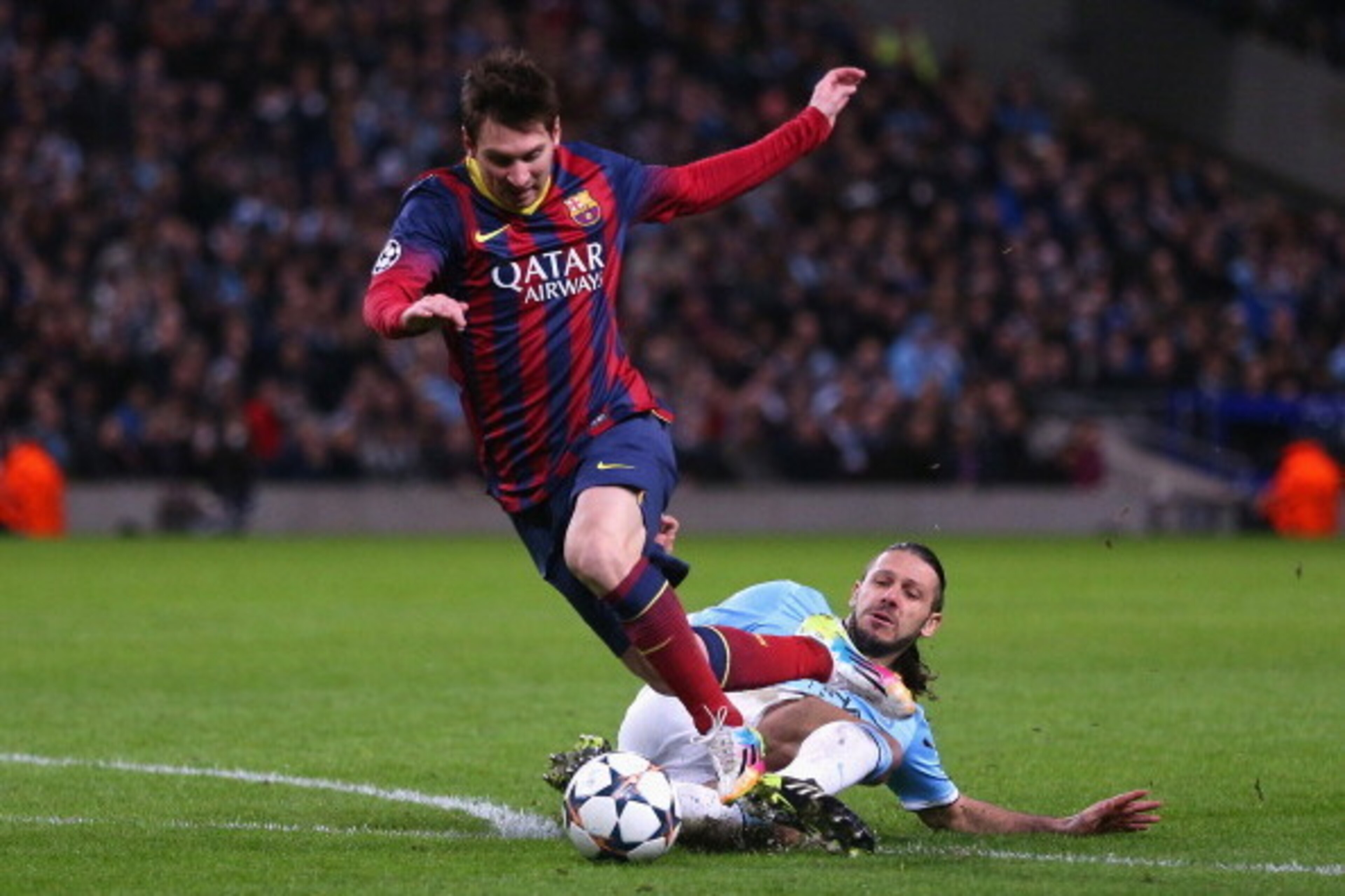 MANCHESTER, ENGLAND - FEBRUARY 18:  Martin Demichelis of Manchester City fouls Lionel Messi of Barcelona to concede a penalty and is subsequently sent off during the UEFA Champions League Round of 16 first leg match between Manchester City and Barcelona a