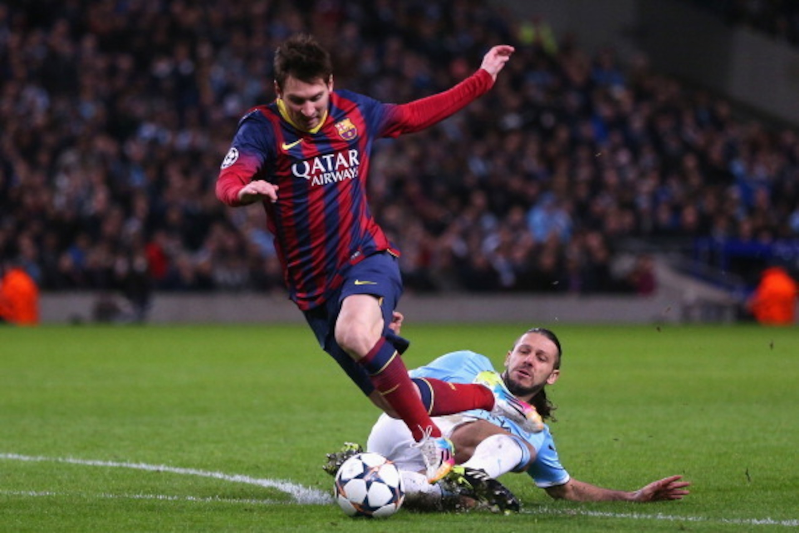 MANCHESTER, ENGLAND - FEBRUARY 18:  Martin Demichelis of Manchester City fouls Lionel Messi of Barcelona to concede a penalty and is subsequently sent off during the UEFA Champions League Round of 16 first leg match between Manchester City and Barcelona a