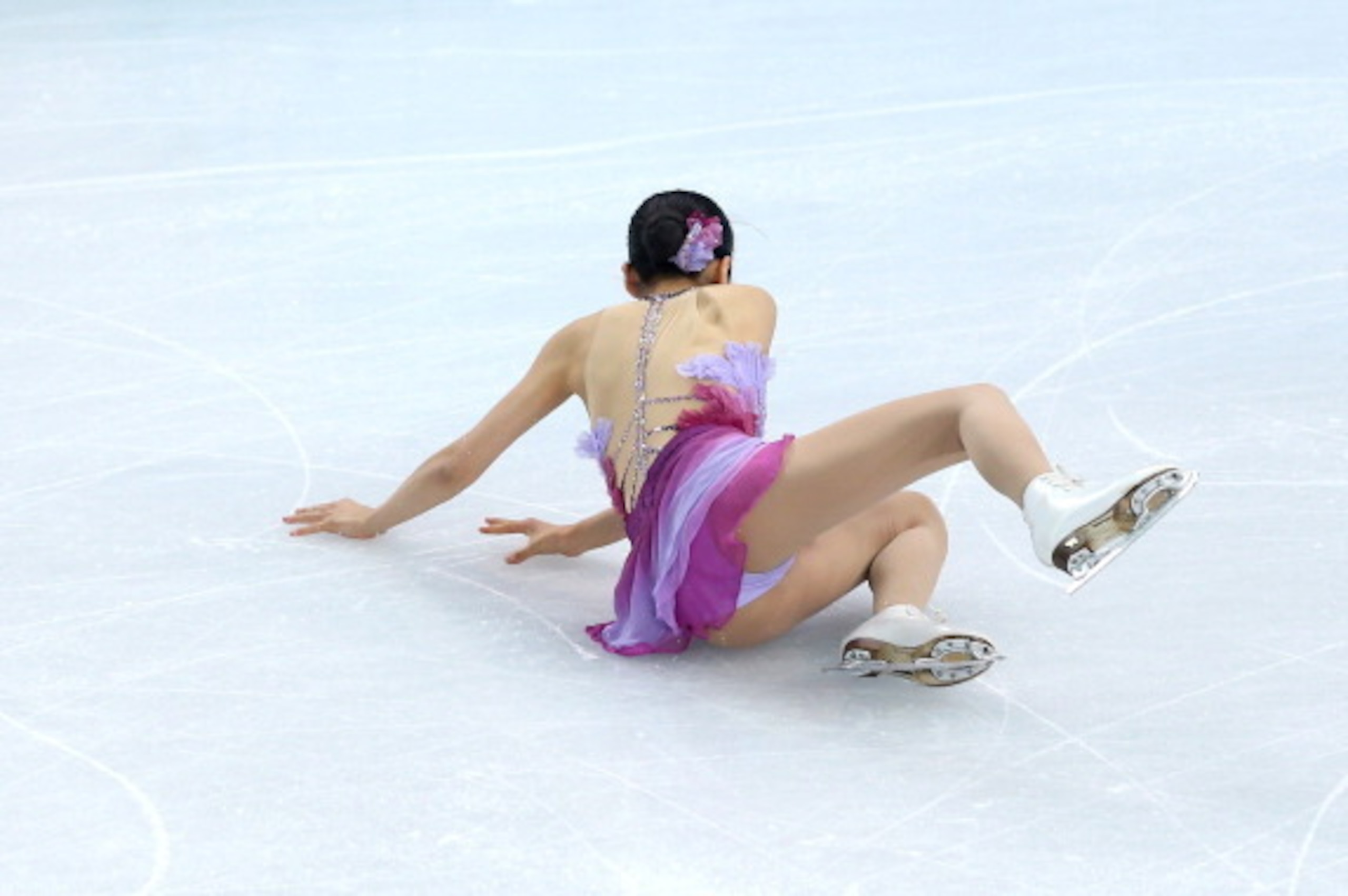 SOCHI, RUSSIA - FEBRUARY 08:  Mao Asada of Japan falls while competing in the Figure Skating Team Ladies Short Program during day one of the Sochi 2014 Winter Olympics at Iceberg Skating Palace on February 8, 2014 in Sochi, Russia.  (Photo by Matthew Stoc