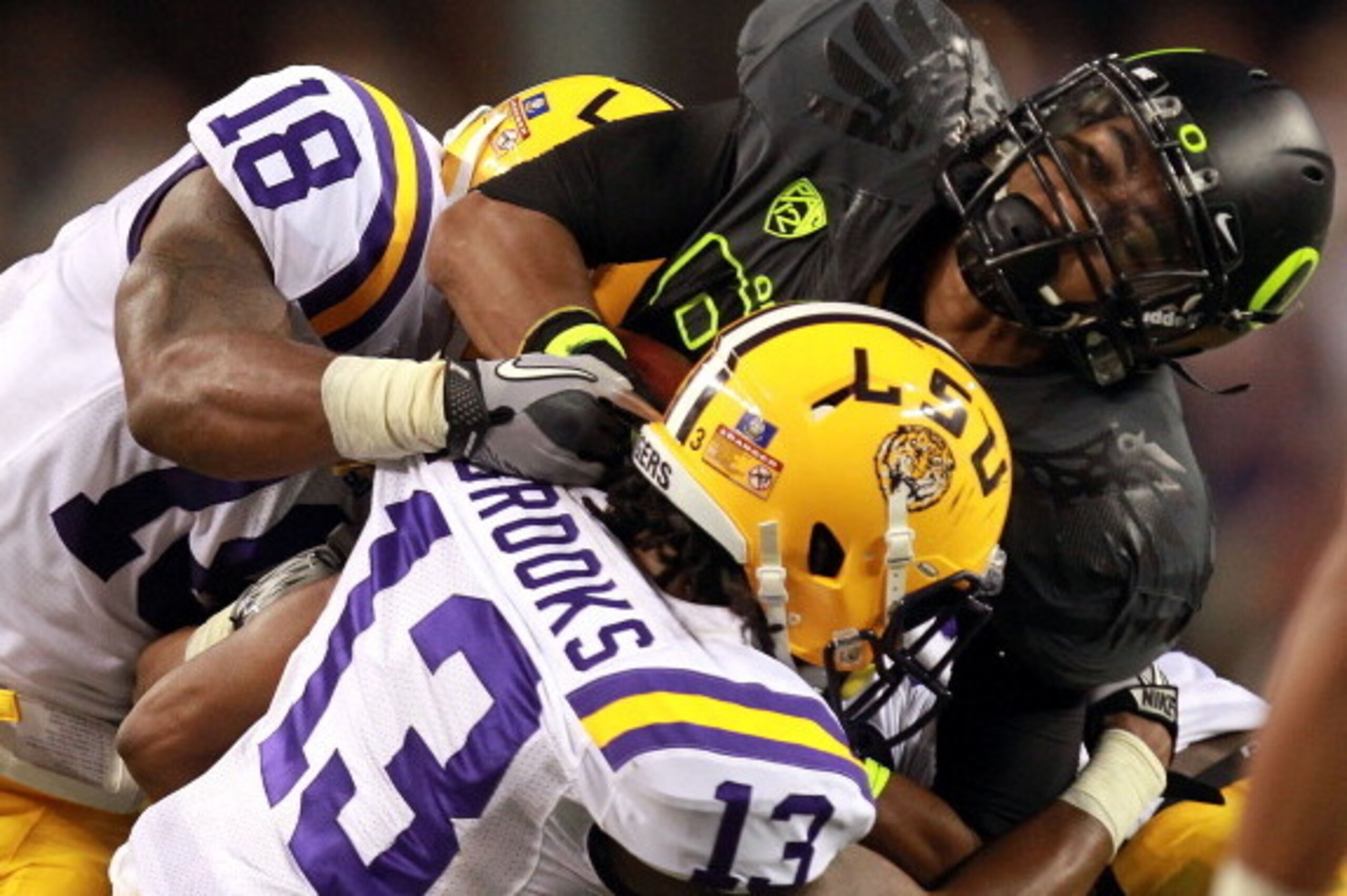 ARLINGTON, TX - SEPTEMBER 03:  Lavasier Tuinei #80 of the Oregon Ducks is tackled by Brandon Taylor #18 and Ron Brooks #13 of the LSU Tigers at Cowboys Stadium on September 3, 2011 in Arlington, Texas.  (Photo by Ronald Martinez/Getty Images)