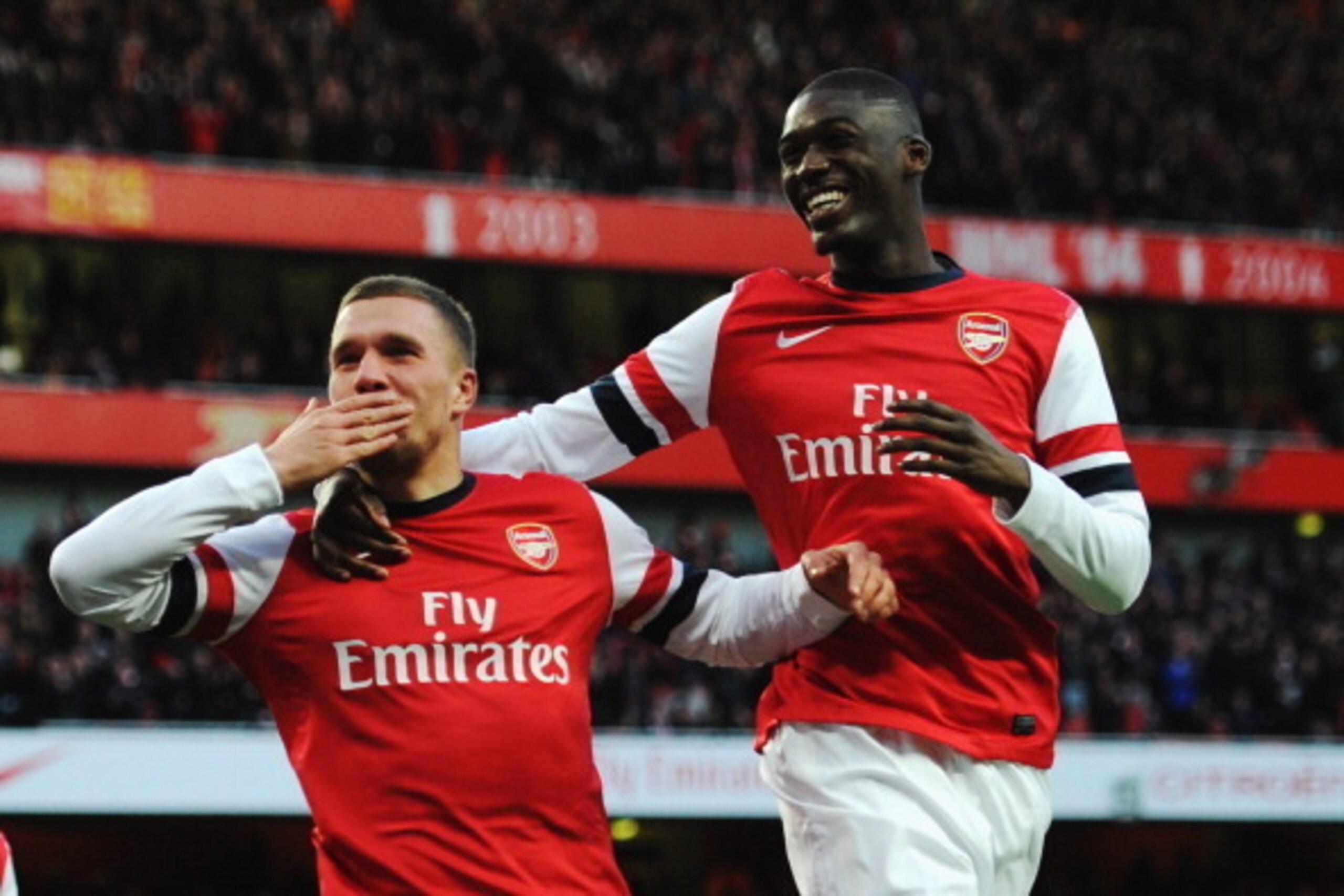 LONDON, ENGLAND - FEBRUARY 16:  Lukas Podolski (L) of Arsenal celebrates with team mate Yaya Sanogo after scoring during the FA Cup Fifth Round match between Arsenal and Liverpool at the Emirates Stadium on February 16, 2014 in London, England.  (Photo by