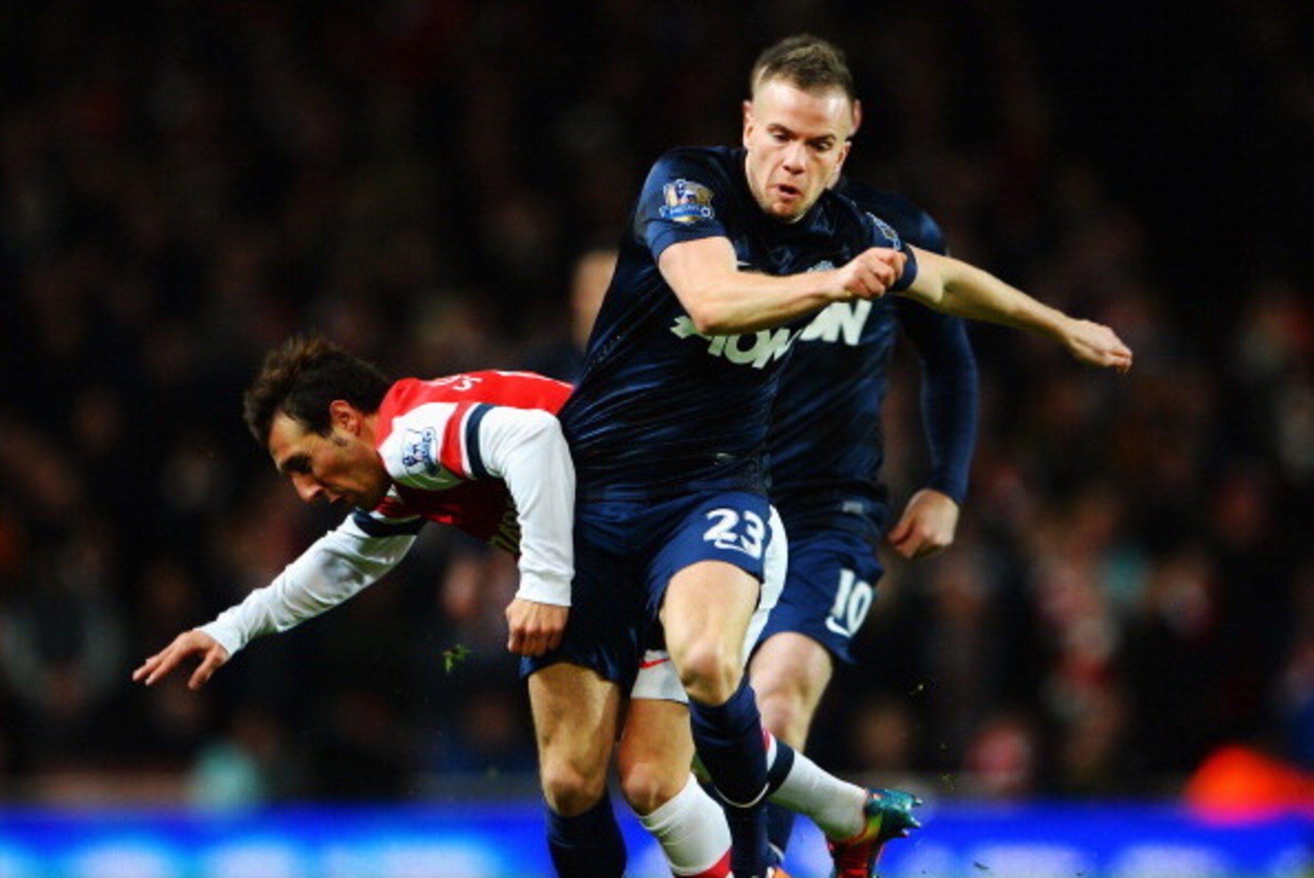 LONDON, ENGLAND - FEBRUARY 12:  Santi Cazorla (L) of Arsenal is challenged by Tom Cleverley (R) of Manchester United during the Barclays Premier League match between Arsenal and Manchester United at the Emirates Stadium on February 12, 2014 in London, Eng